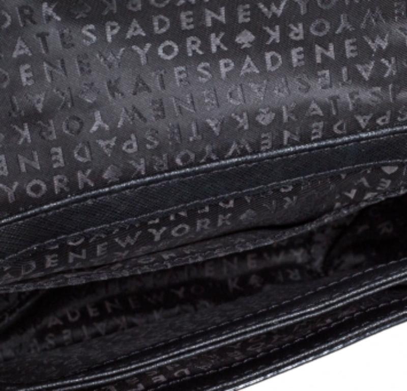Disfrutarás desfilando con este bolso de Kate Spade. Está confeccionado en piel negra y cuenta con una correa para el hombro y una placa con el logotipo en la solapa. Está equipada con un interior forrado de nailon pensado para guardar todos tus
