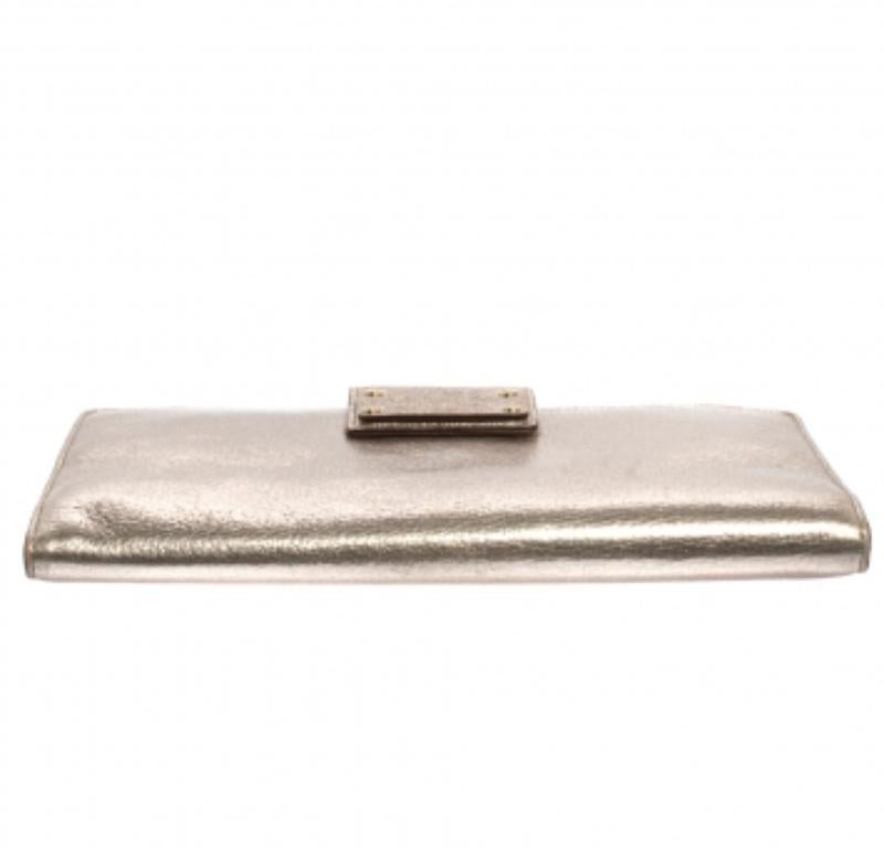 Fendi, the Italian fashion house brings you yet another gorgeous accessory with this clutch. It has been crafted from shimmery gold leather and styled with a flap that opens to a leather & fabric-lined interior. It is finished with gold-tone