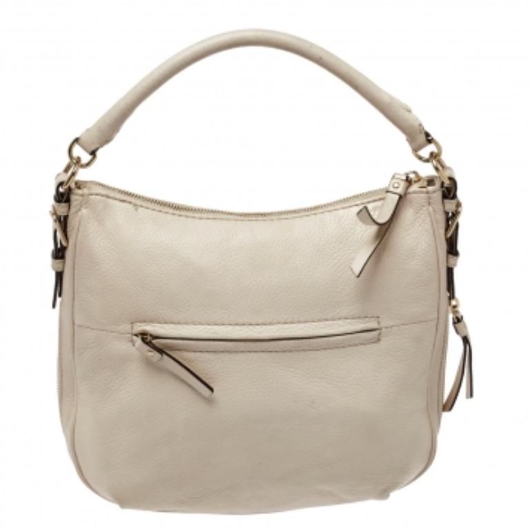 Diese Tasche von Coach ist aus hochwertigem, weißem Leder gefertigt und verfügt über eine gut bemessene Innenausstattung aus Stoff mit einer kleinen Tasche für Ihren Komfort. Diese Elle Hobo ist mit einem goldfarbenen Reißverschluss, einer