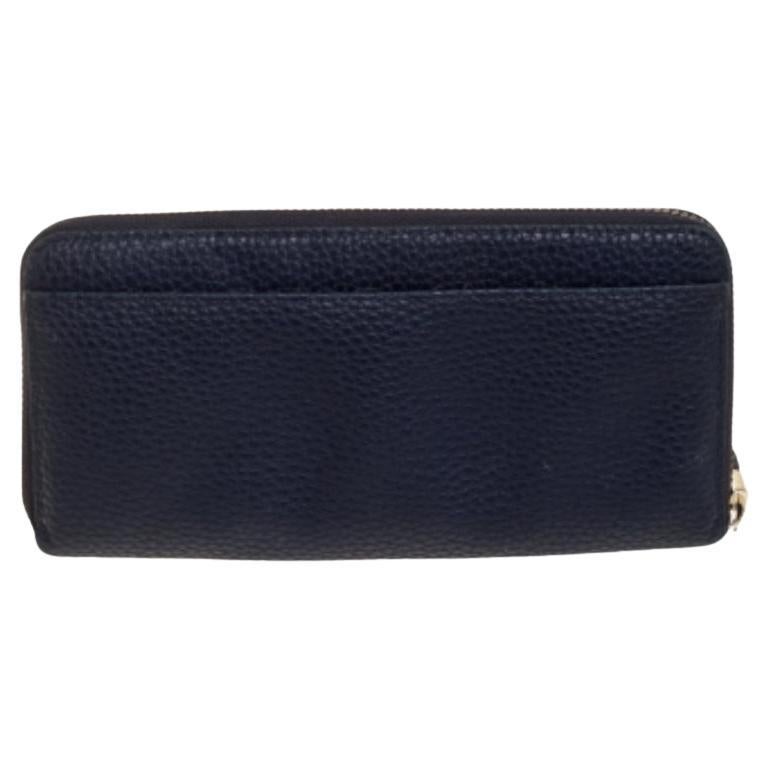 Designed to perfection and crafted from fine quality leather, this wallet will be your go-to accessory. From the house of Kate Spade, it is crafted in a navy blue hue. The creation is secured by a zip-around closure and complete with the bow motif