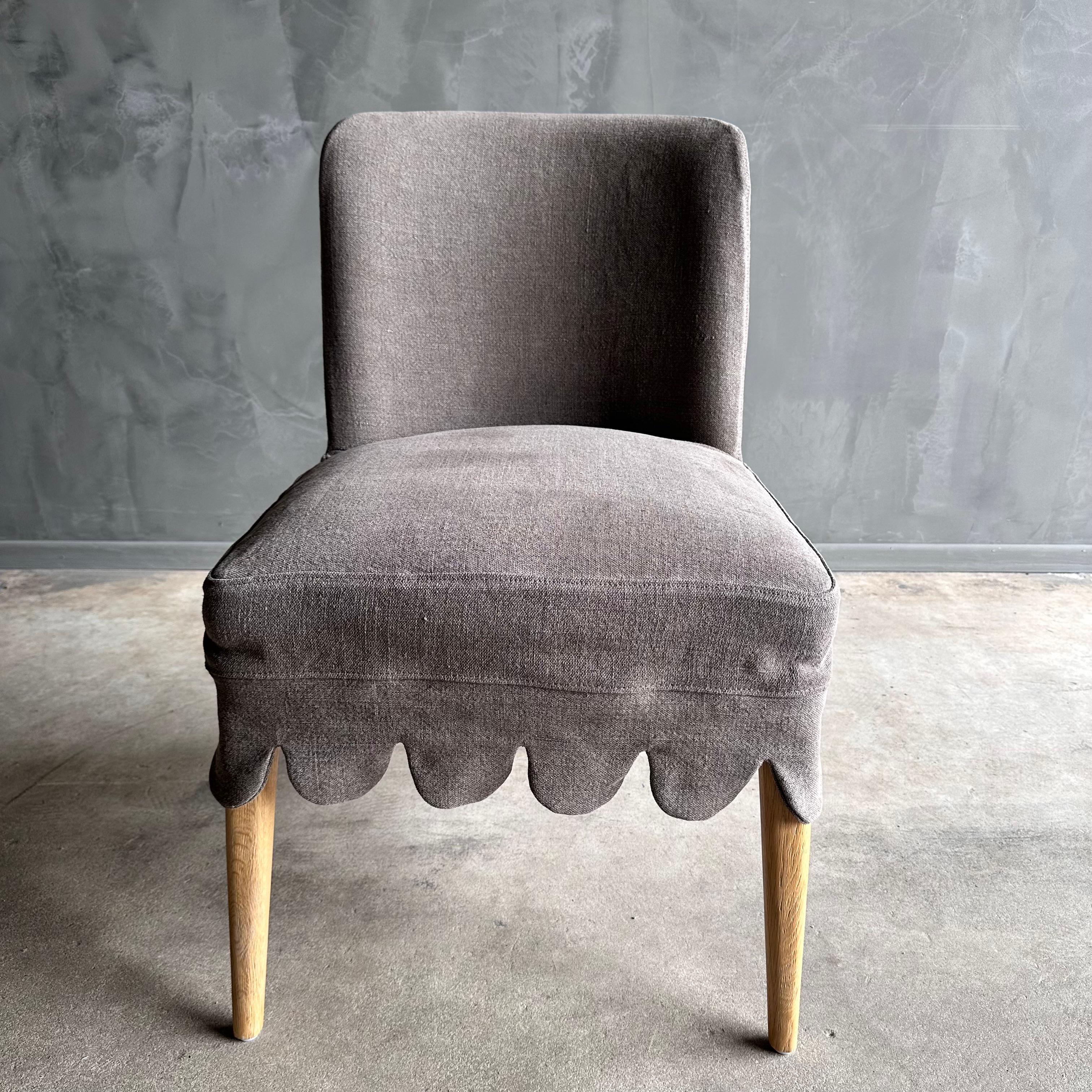 Kate Linen Slip Covered Dining Chair
This linen slipcovered dining chair is a stylish and comfortable addition to any dining room. Made from heavy-weight fabric with a soft hand, it features scalloped detailing for a touch of elegance. The chair is