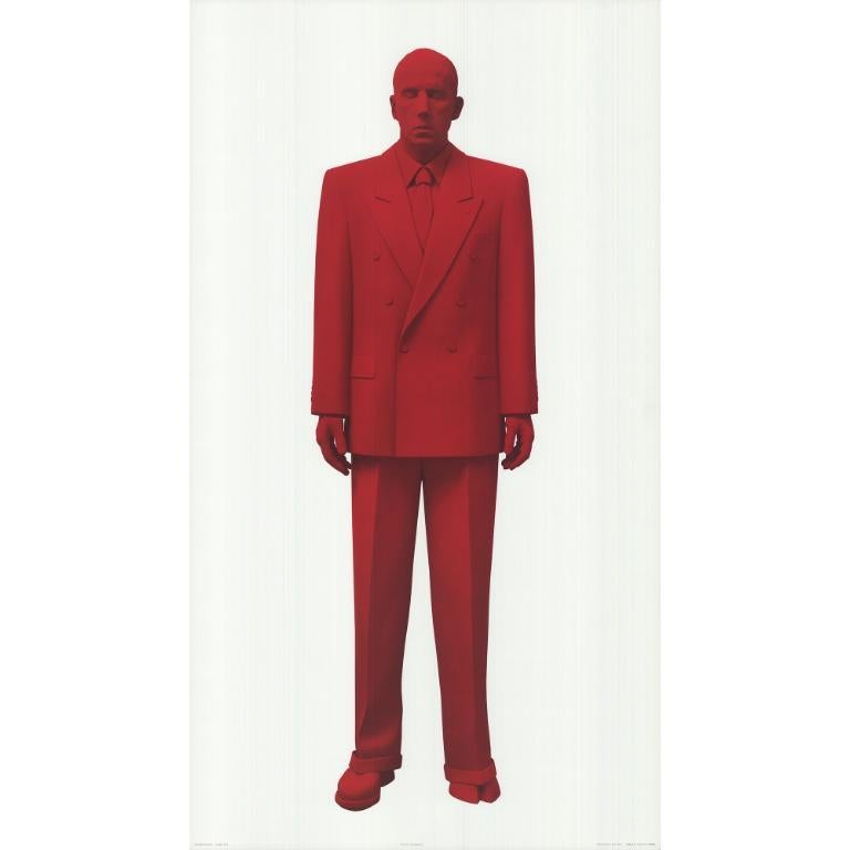 La obra de Katharina Fritsch, en la que aparece un hombre alto vestido totalmente de rojo, con un pie transformado en pezuña hendida, es un ejemplo convincente de su exploración de la interacción entre lo familiar y lo extraño. La pezuña hendida, a