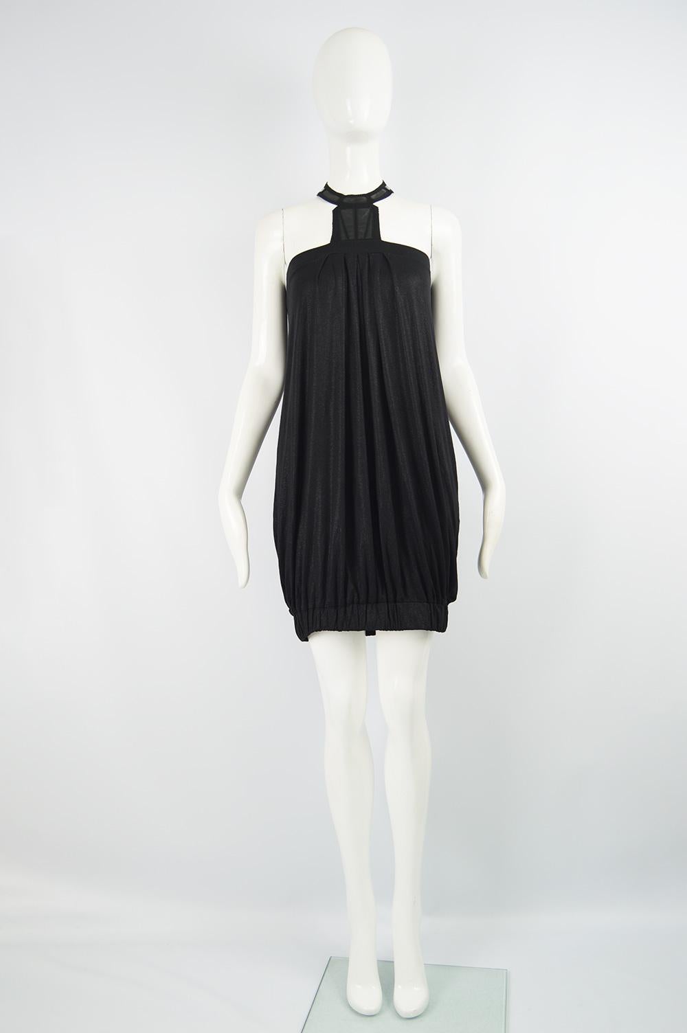 A chic Vintage Katharine Hamnett  mini dress from the late 90s  / early 00s. In  black stretch rayon jersey which has a sparkly effect throughout, a bubble shape created by two elasticated bands and a vinyl appliqued halter neck that ties at the