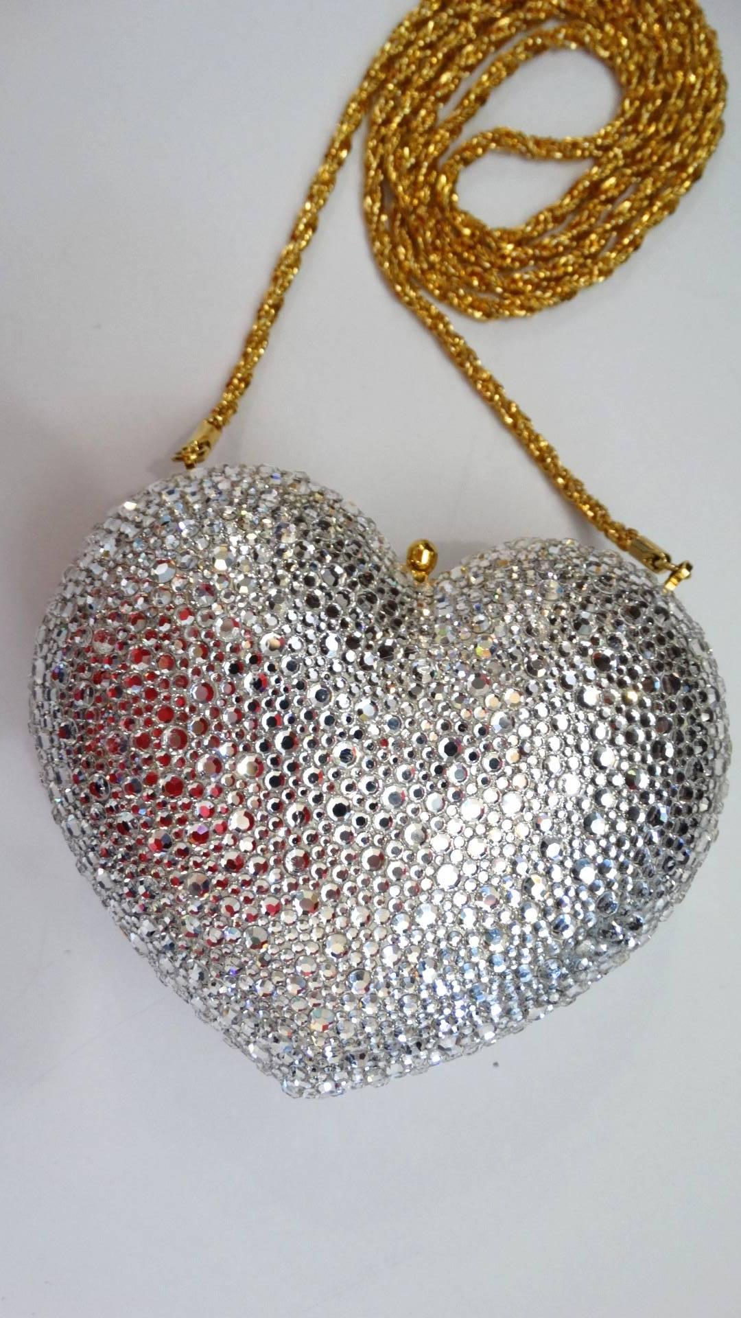 Add some sparkle to your evening attire with this adorable Kathrine Baumann Beverly Hills heart bag! Hard metal heart shaped frame covered in silver Swarovski crystals contrasted with gold metal hardware. The interior is fully lined with matching