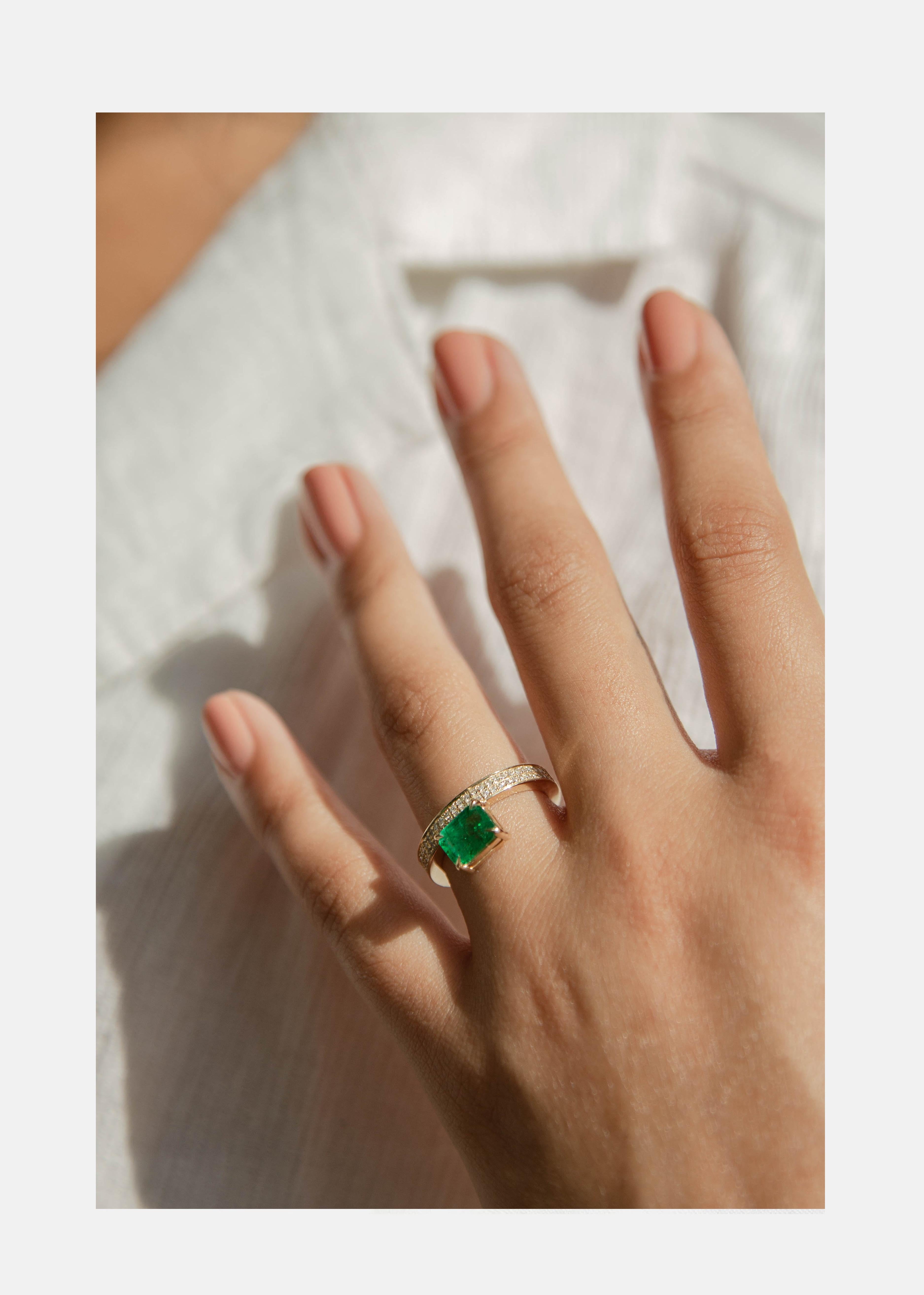 Crafted of polished 18k yellow gold, our signature 'Float' setting radiates modern timelessness showcasing a 1.84ct Columbian emerald on a double row pavé diamond band. Pavé goes 75% around band approximately 0.34tcw. The Muzo emerald is set