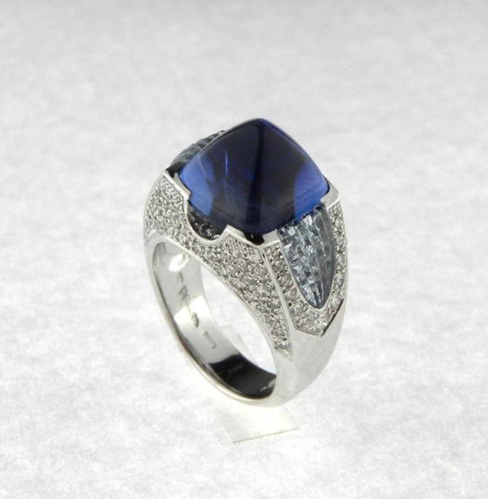 Behold a masterpiece of Italian craftsmanship – an original creation by the renowned jeweler Scavia. This exquisite ring, crafted in lustrous 18K white gold, showcases a sleek silhouette that elegantly frames a mesmerizing deep blue sugar loaf