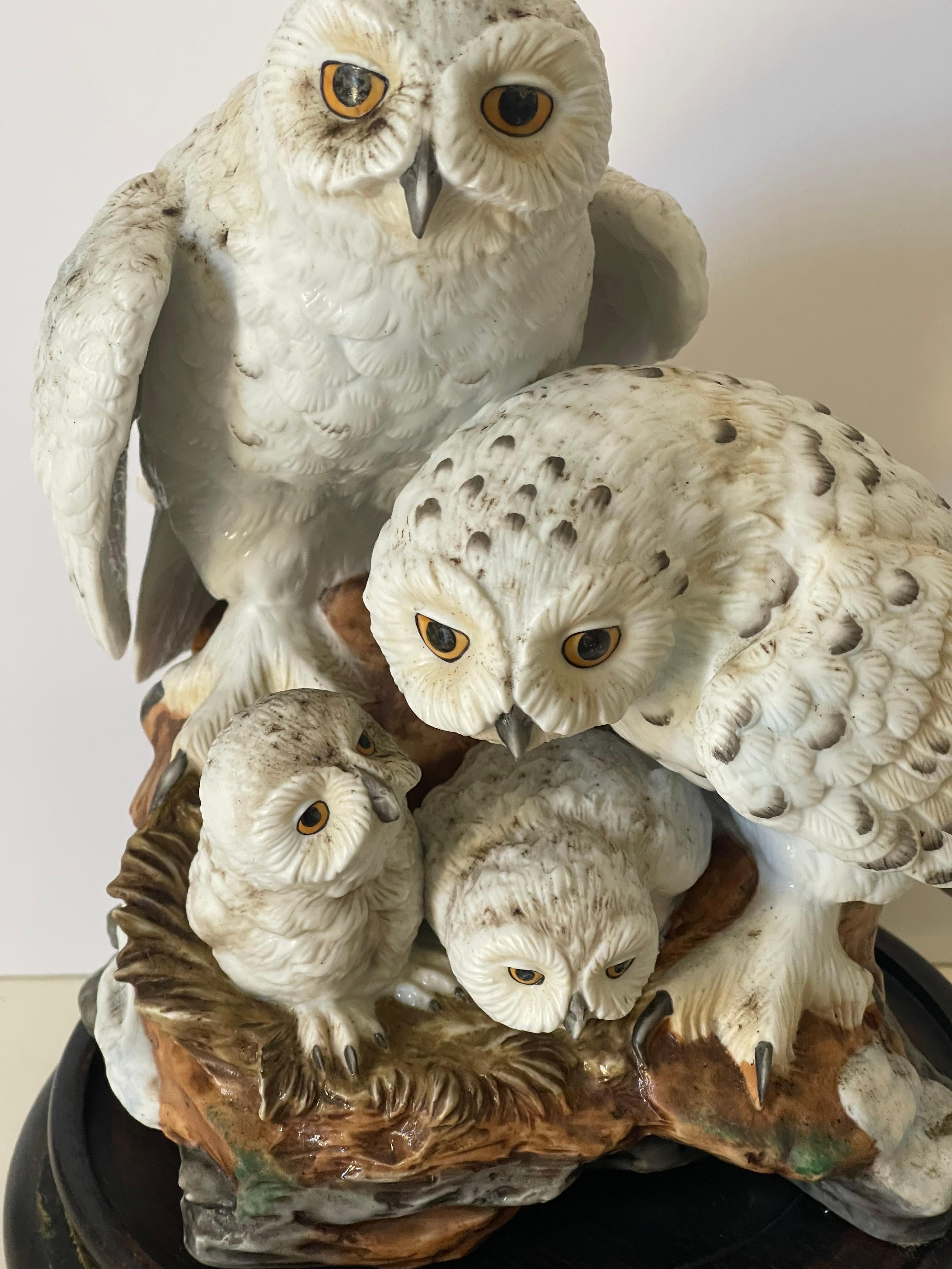 Gufi innevati scultura naturalistica in porcellana di bisquit del giapponese Katsumo Ito Denburry. Rappresentazione realistica di una splendida famiglia di gufi delle nevi. Posizionato su un supporto in legno intagliato. Grande pezzo da collezione.
