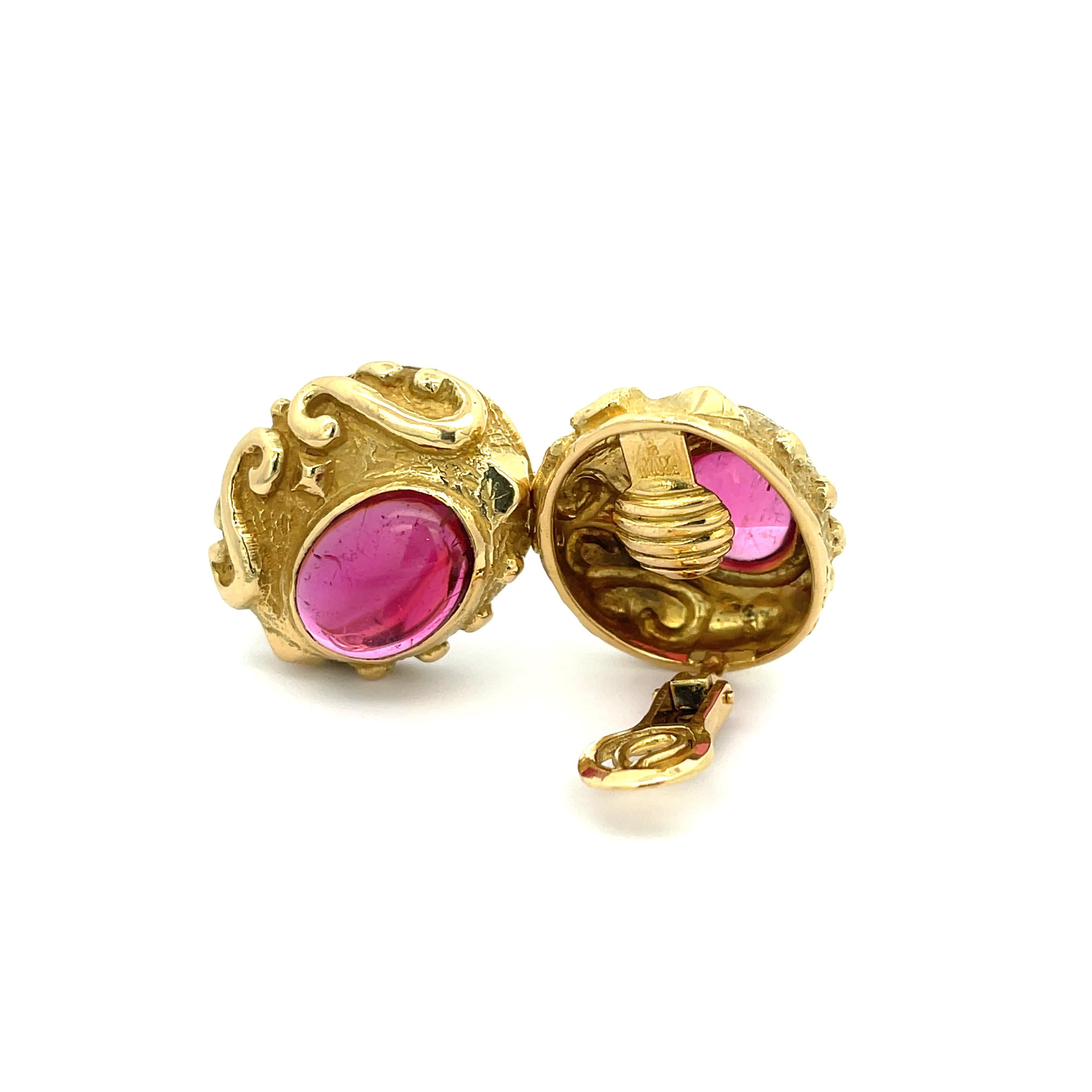 Katy Briscoe Cabochon Rubellite Earrings in 18K Yellow Gold. The earrings feature a matched pair of vibrant pink Rubellites with 15.52ctw. The earrings are accented by heavy scrollwork. 
26.7 grams
