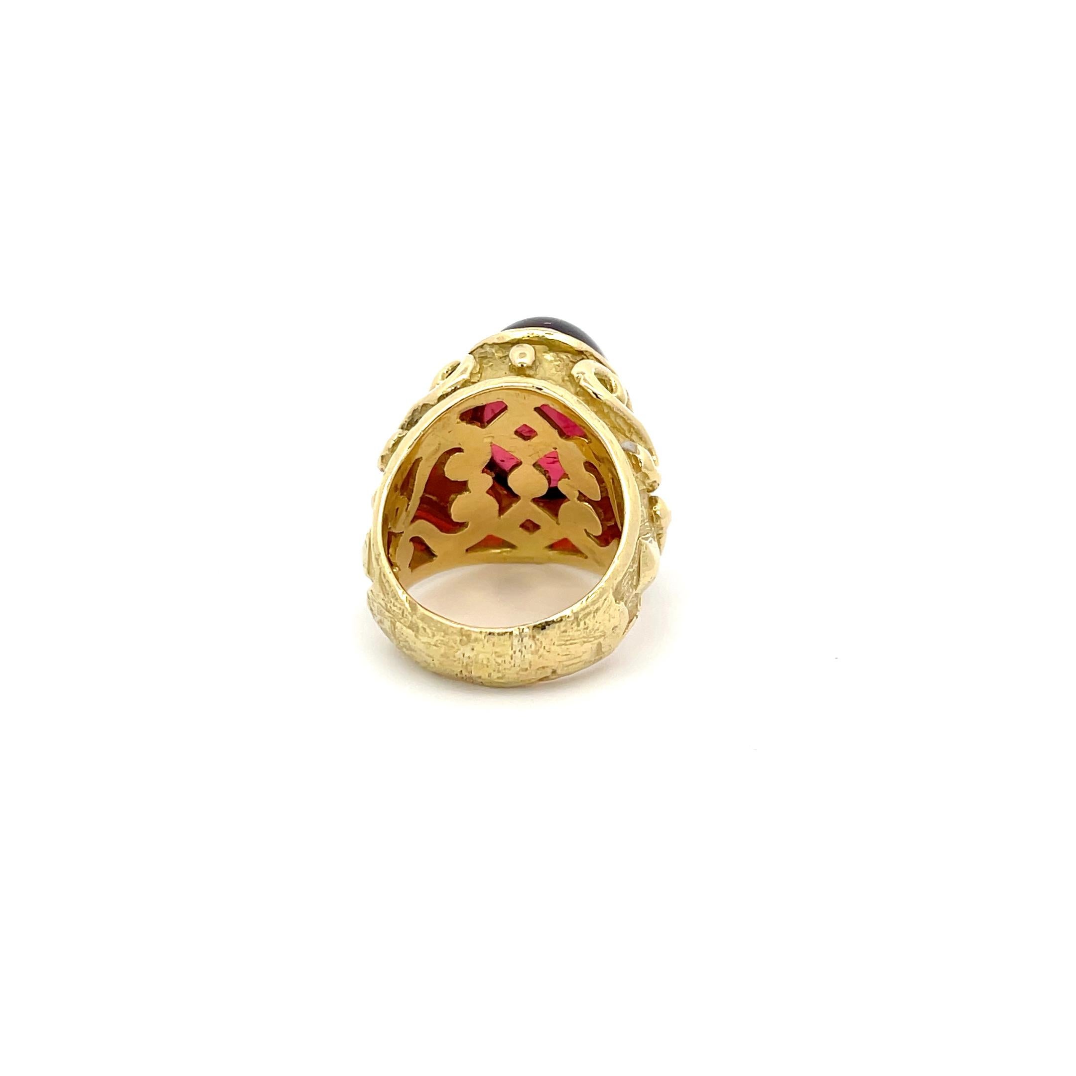 Katy Briscoe Cabochon Rubellite Ring in 18K Yellow Gold. The ring features a 20.41ct cabochon cut rubellite that has a vibrant raspberry pink color. The ring is accented by heavy scrollwork details. Size 8.5
25.1 Grams 