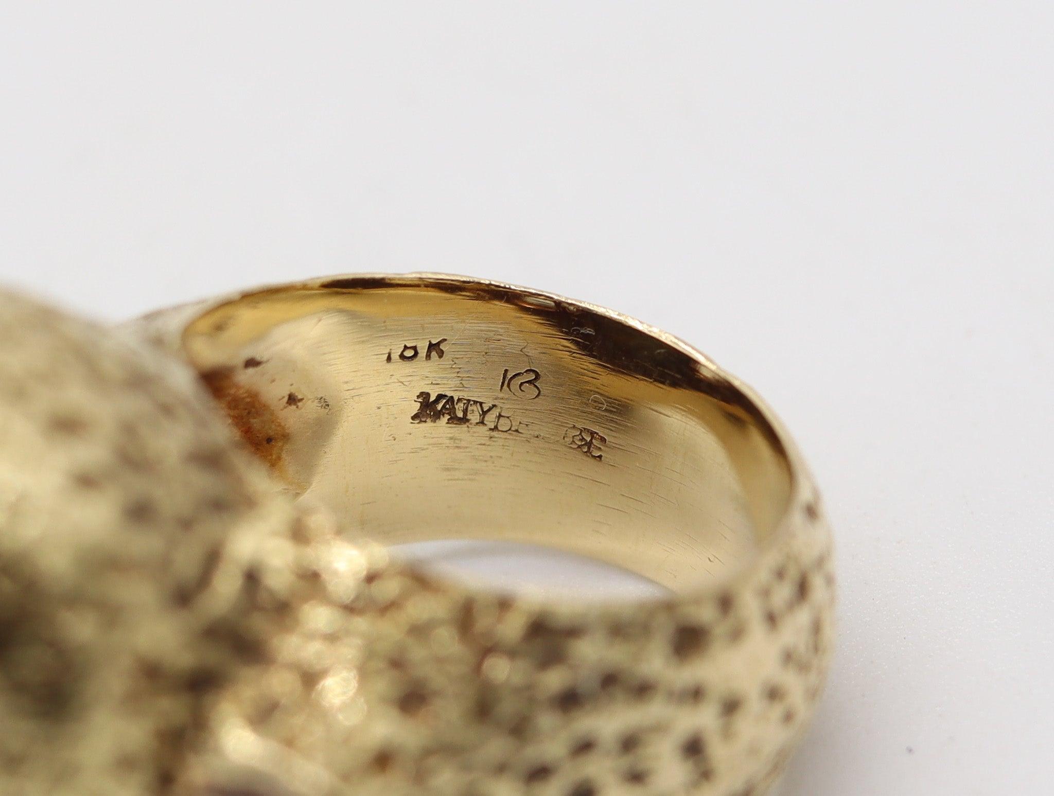 Une bague de cocktail audacieuse avec turquoise conçue par Katy Briscoe.

Il s'agit d'une bague de cocktail massive et audacieuse créée par la designer américaine Katy Briscoe dans les années 1990. La bague est une pièce unique, fabriquée de main de