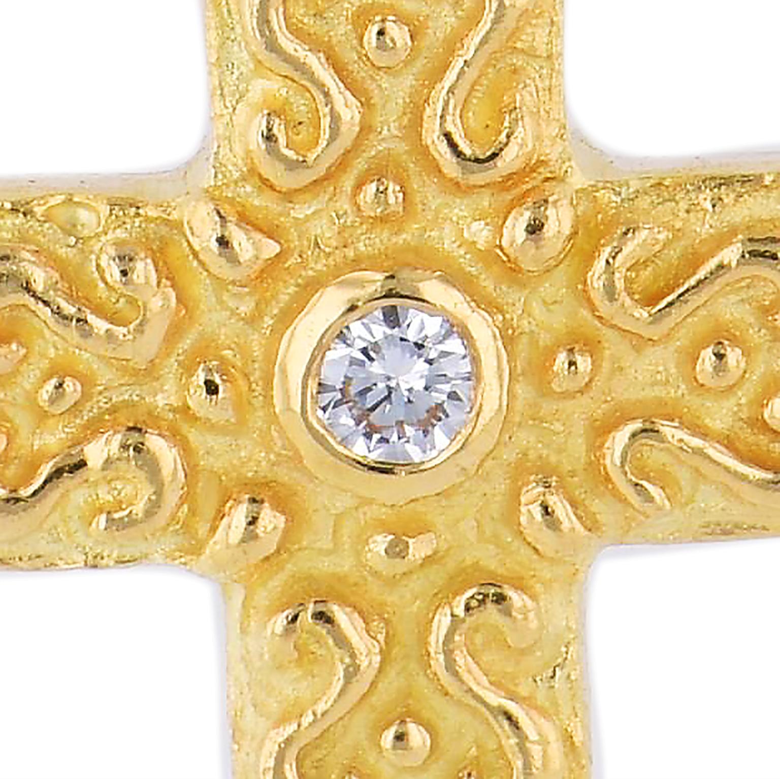 Enjoy this previously loved Katy Briscoe 18 karat yellow gold cross with removable hinge on bale. This pendant features a bezel set diamond at center with a total weight of 0.17 carat (G/SI1) strung on a 16 inch link chain necklace.