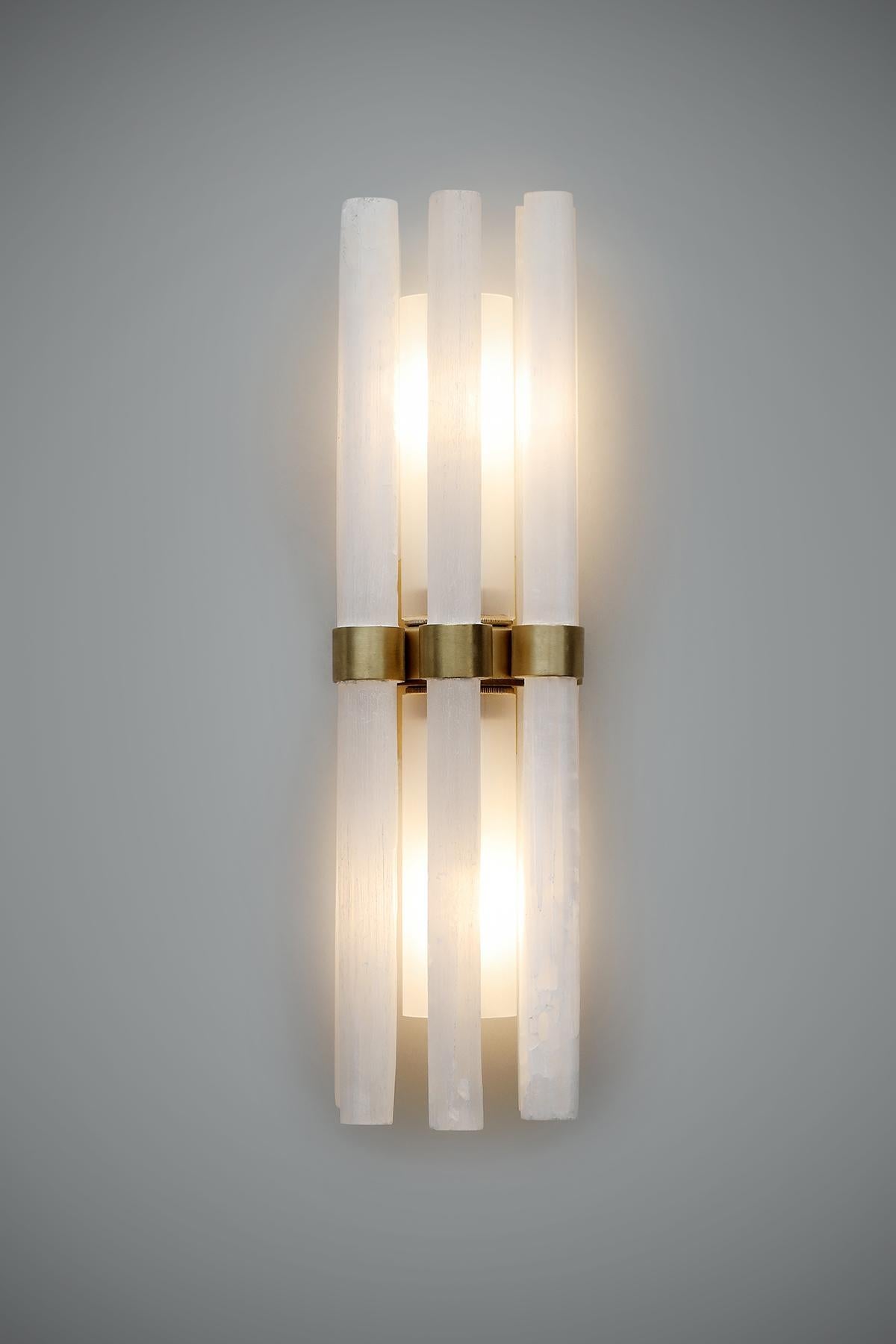 Our handcrafted Katz Wall Light adds contemporary sophistication to any room. Using rock crystal rods to surround the light, it create a beautiful glow. Boasting clean lines and a structured shape it is created using hand-crafted bronze to gently