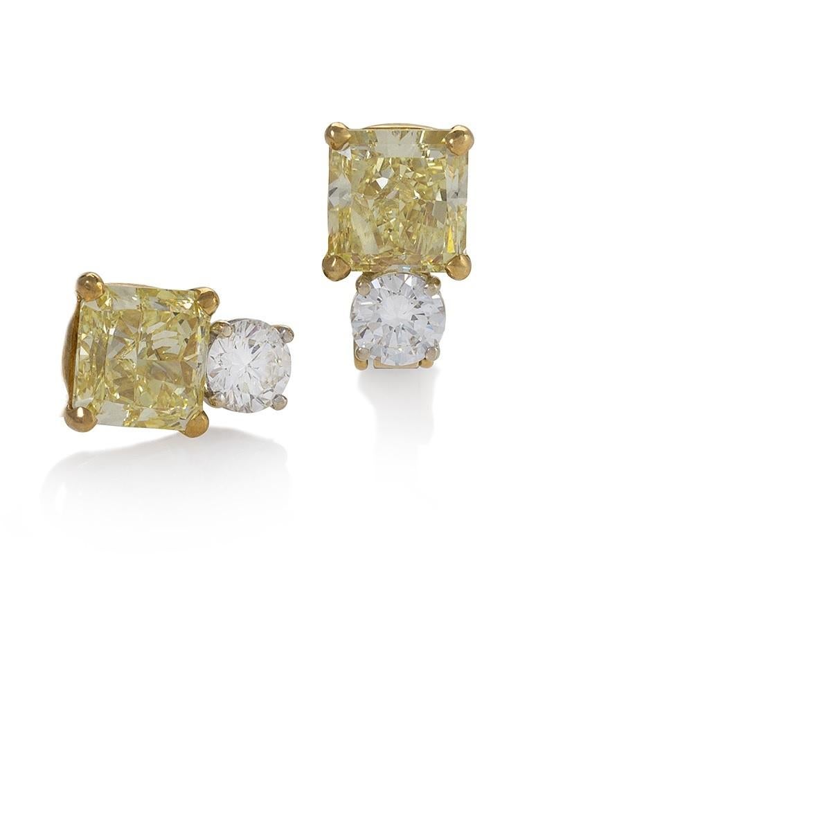 These diamond earrings, each set with an over three-carat fancy yellow, cut-corner square, brilliant-cut diamond, paired with a near-colorless round brilliant-cut diamond, are the ideal statement for modern simplicity and elegance. While the round