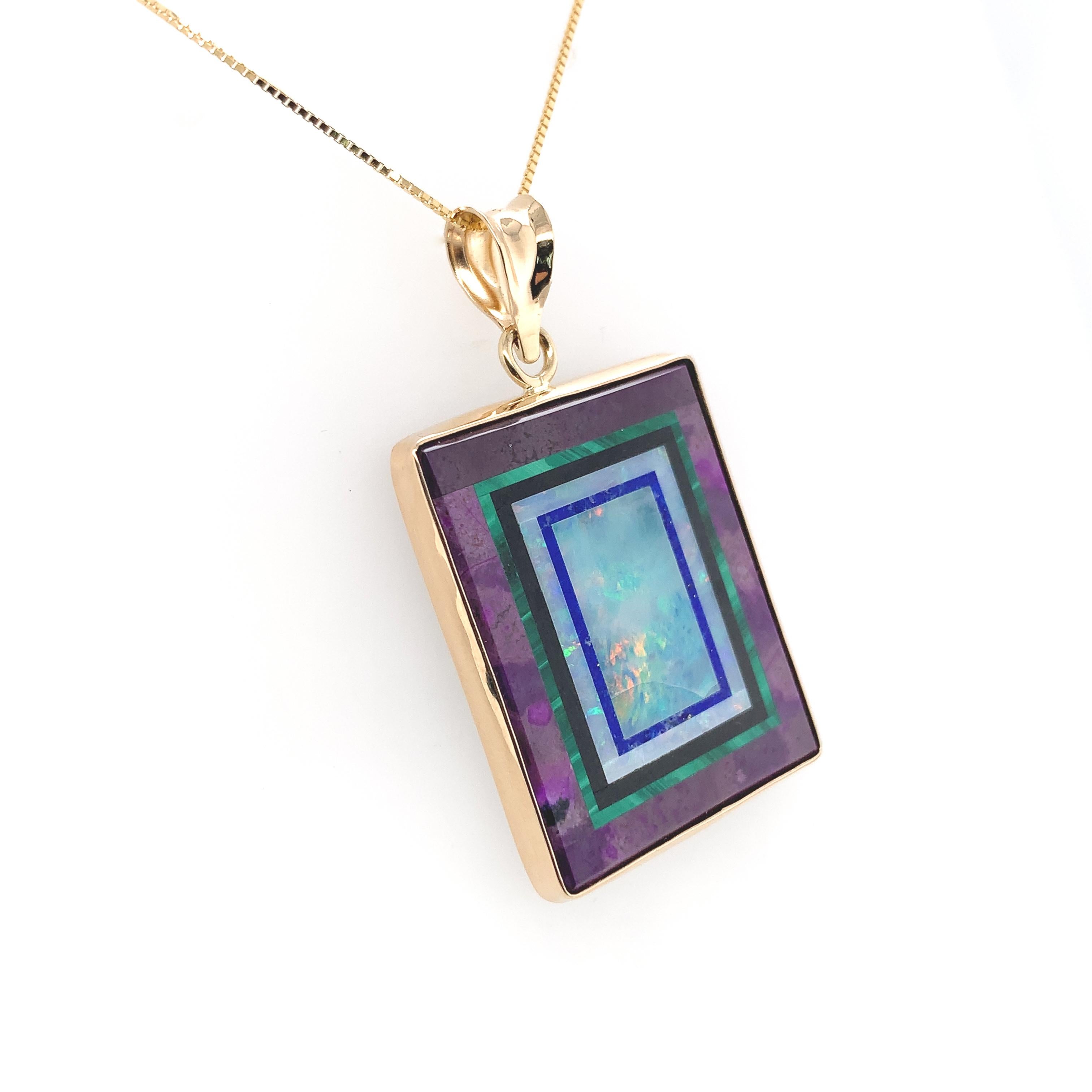 Pendente Intarsia in oro giallo 14K realizzato con opale intarsiato in sugilite con malachite, lapis e giada nera.  L'intarsio è stato realizzato e firmato da Jim Kaufmann. La pietra intarsiata misura circa 20,5 mm x 25,5 mm e pesa 27,06 carati.  Il
