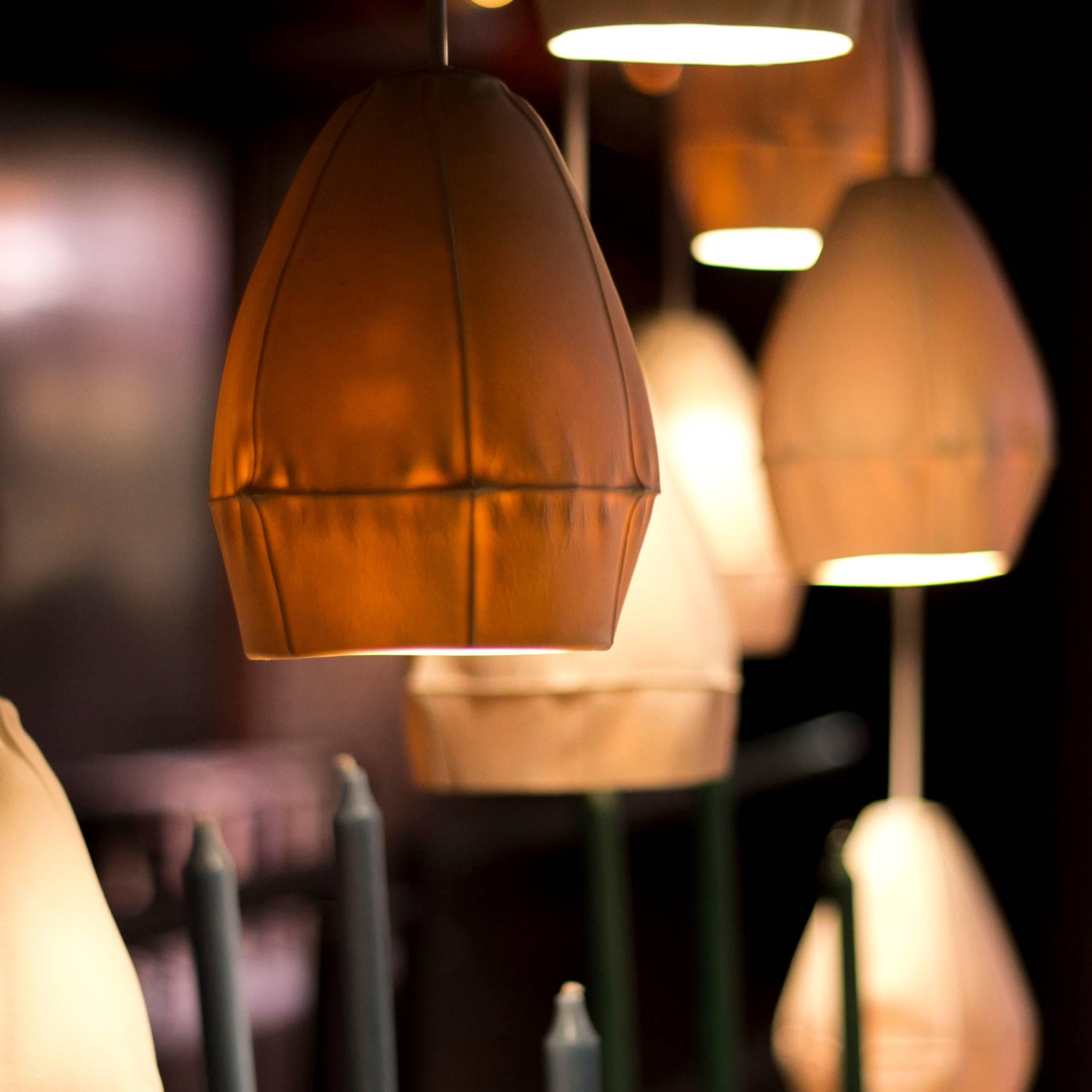 Le lampade a sospensione Kawa di Souda sono realizzate in porcellana colata direttamente in dozzine di stampi in pelle che danno vita a paralumi in ceramica altamente unici. Le luci a sospensione ultimate sono dinamiche e altamente insolite,