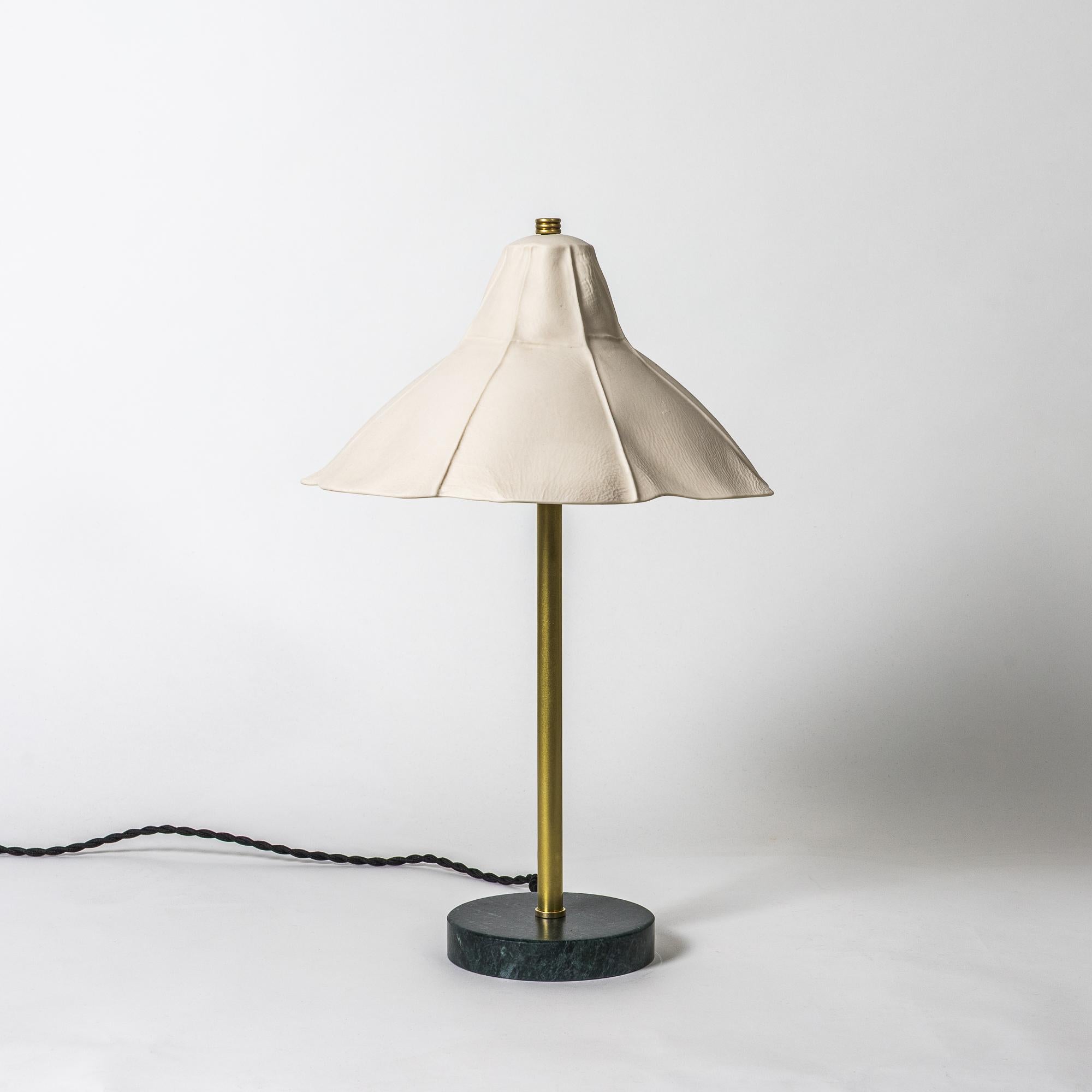 Lampada da tavolo Kawa 03 di Luft Tanaka
Una lampada da tavolo portatile plug-in con un diffusore in porcellana fusa in pelle, dalla forma organica e asimmetrica, che proietta una luce calda e confortante quando viene accesa. Il diffusore è