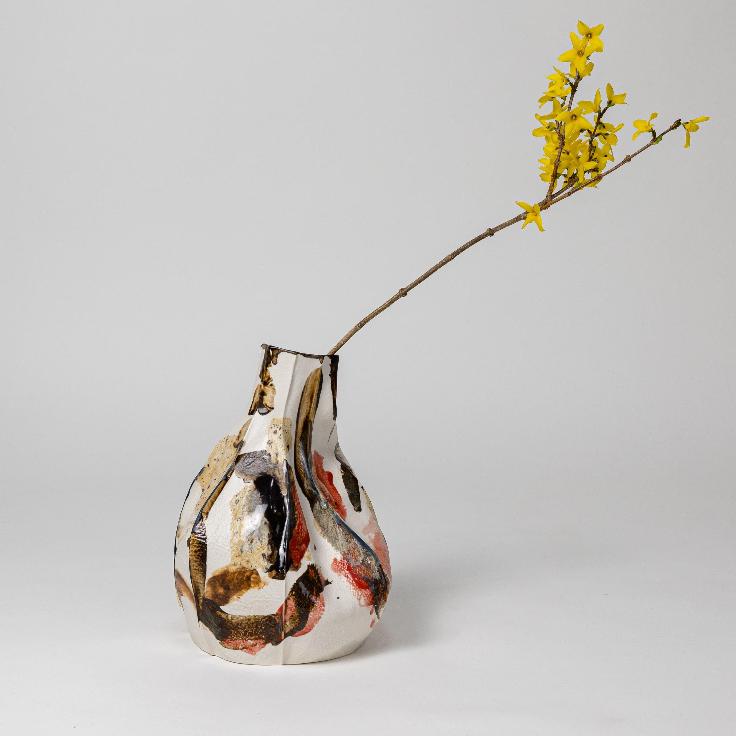 Organically shaped porcelain vase with abstract multicolored glaze on the exterior surface. 

This item is a SECOND QUALITY item. This piece came out of the kiln with a crack on the bottom of the piece. The crack was patched and fixed so the piece