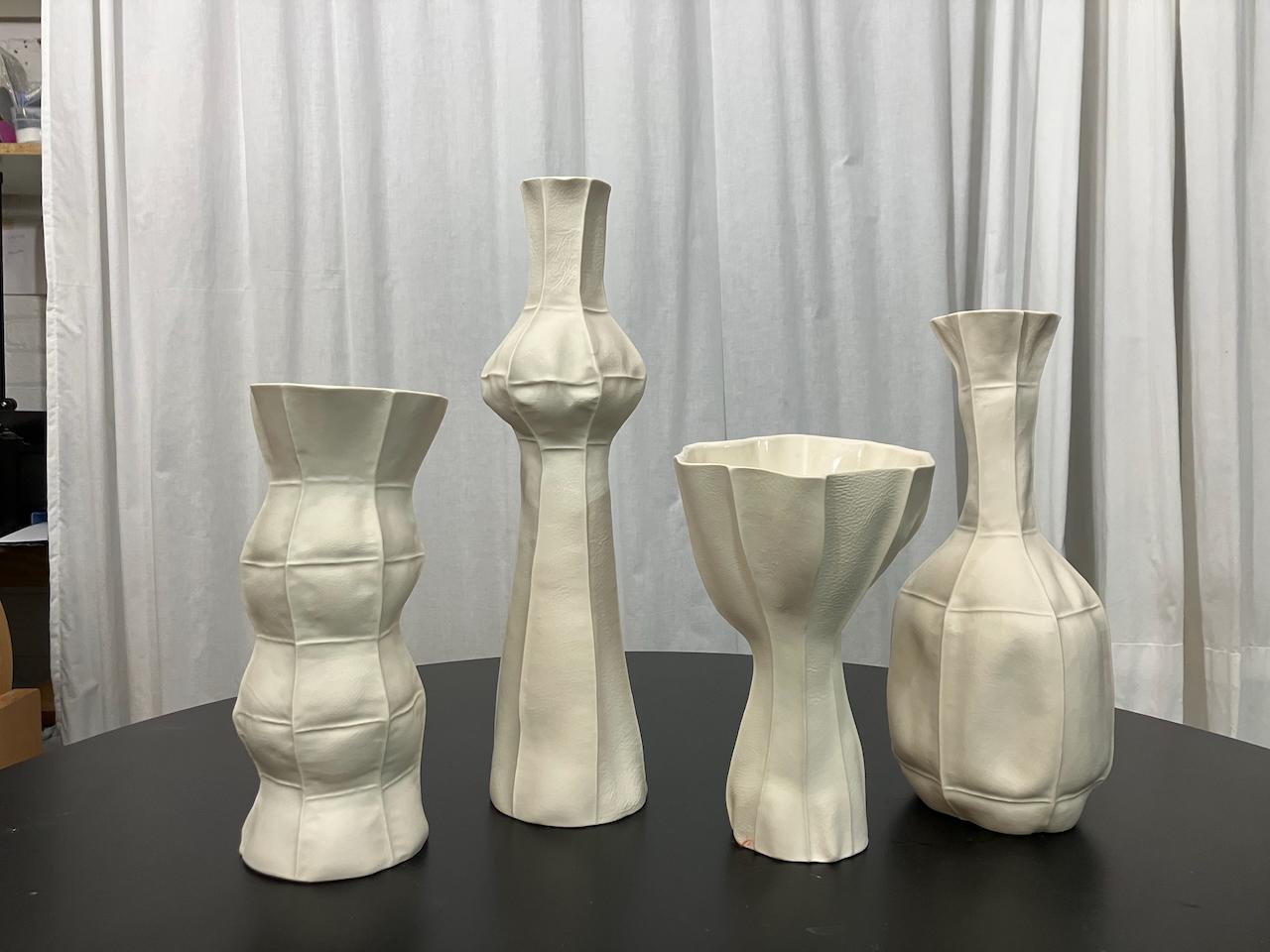 Groupement de vases uniques de la série Kawa, fabriqués à la main par Luft Tanaka Studio en coulant de la porcelaine dans des moules en cuir cousus. 

Vendu par lot de 4 pièces.

En raison du processus de production, chaque article est unique. 

Les