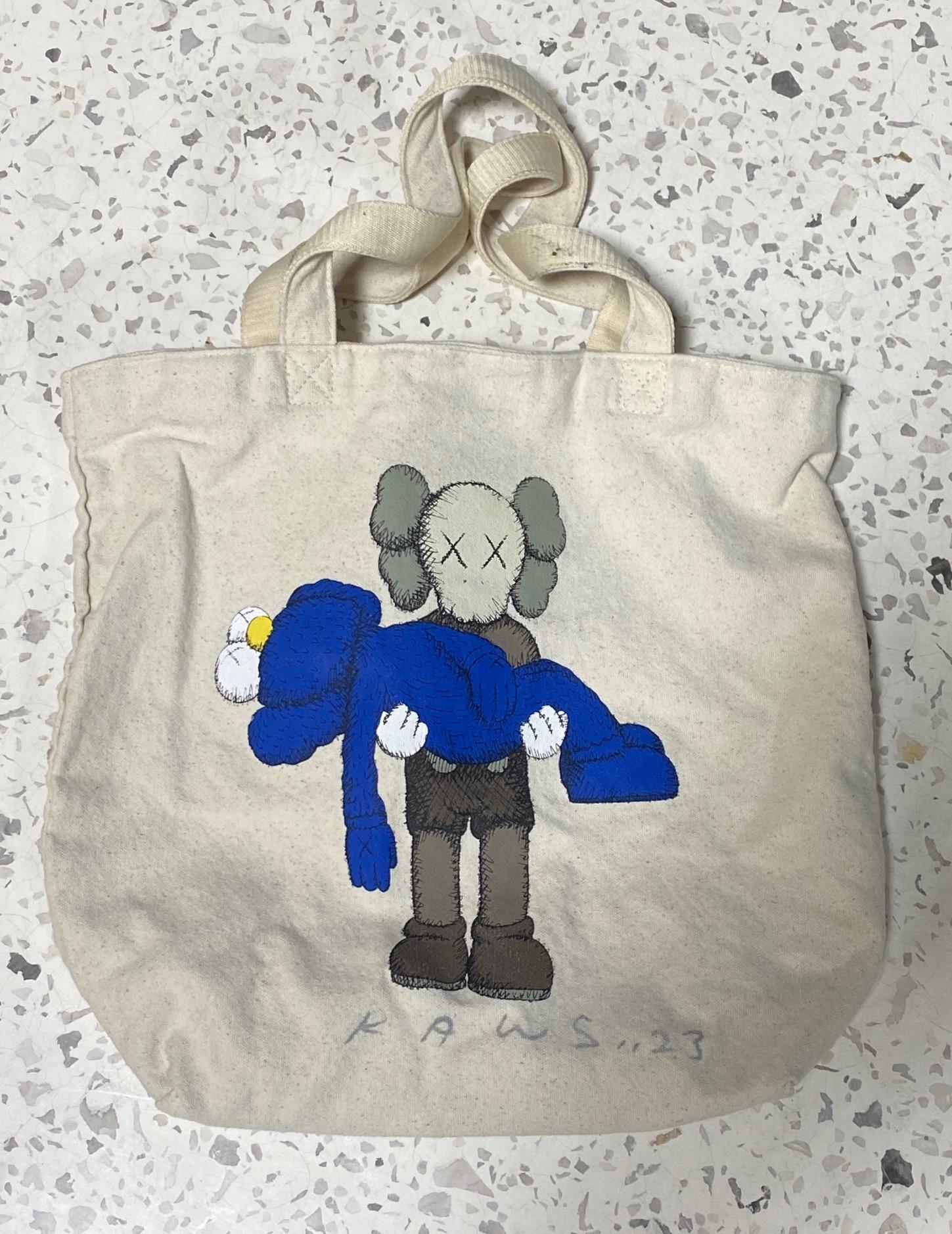 A quite rare signed tote shopping bag by world-renowned contemporary artist and New York-based sensation KAWS (Brian Donnelly). Art critics have universally and consistently compared KAWS to such historic masters as Jean-Michel Basquiat and Keith