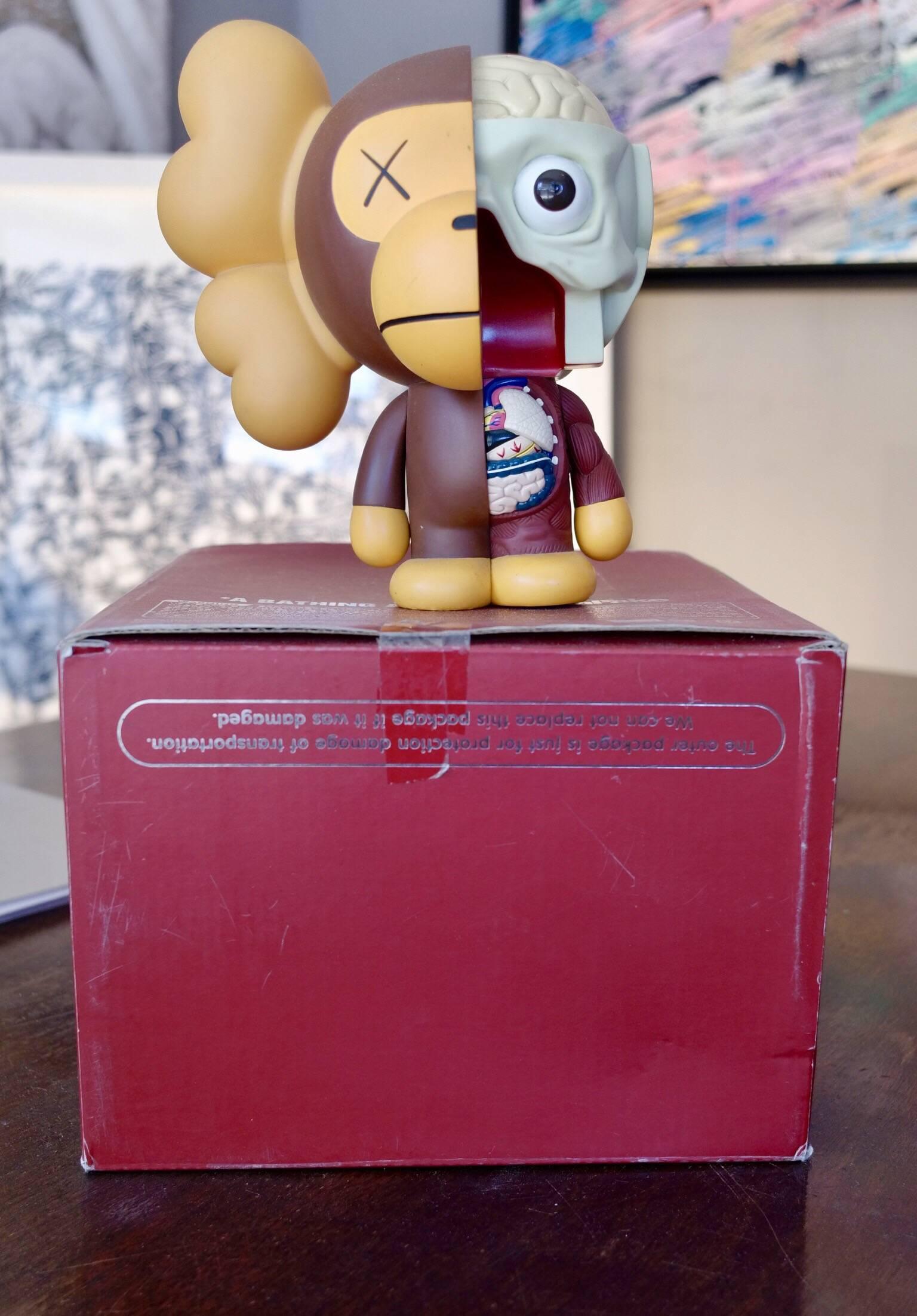 Kaws, Milo, 2011. 
A bathing ape. OriginalFake. 

Painted cast vinyl. 
In its original packaging / box. 
Produced and manufactured Medicom Toy, China.