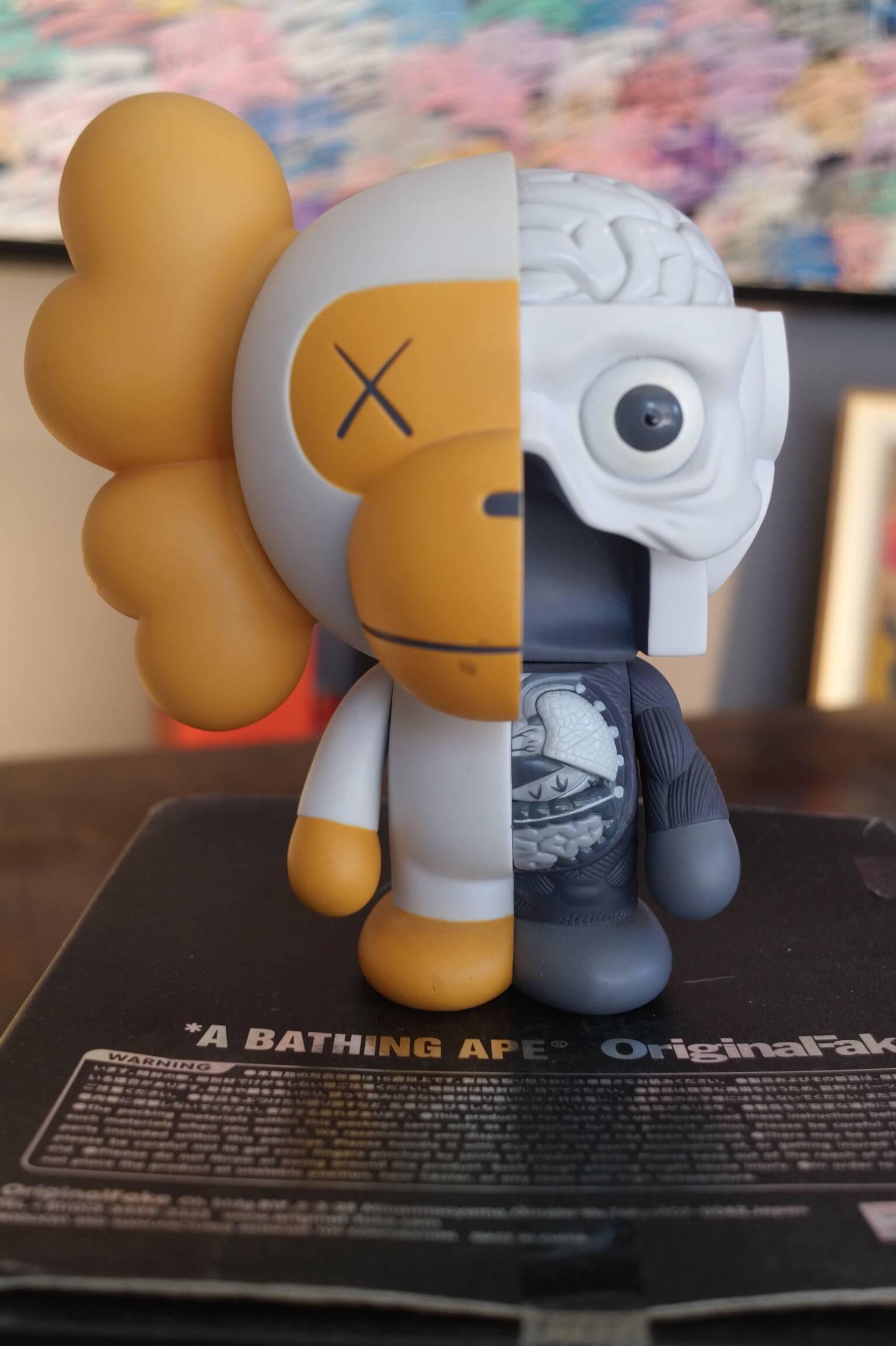 Kaws, Milo, 2011. 
A bathing ape. OriginalFake. 

Painted cast vinyl. 
In its original packaging / box. 
Produced and manufactured Medicom Toy, China.