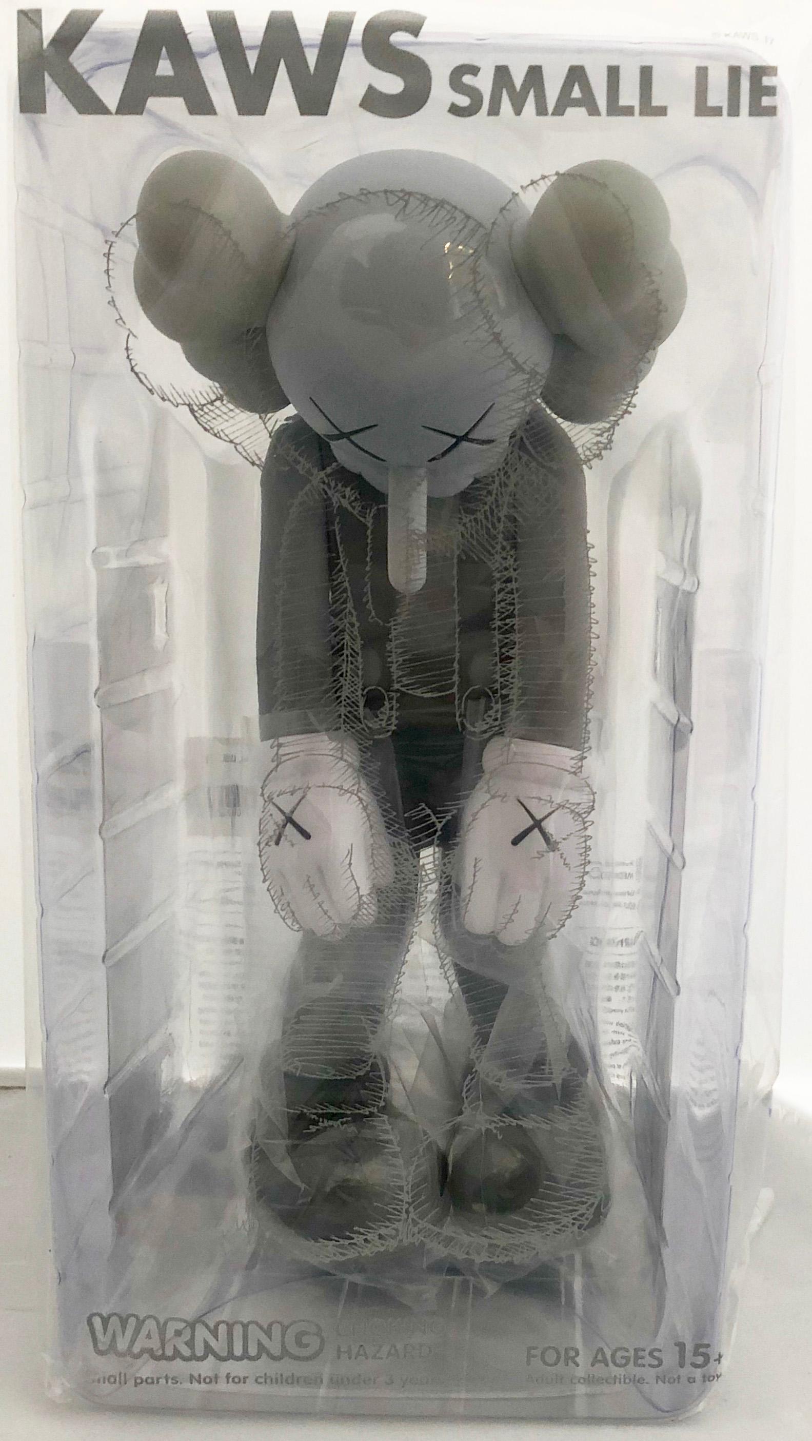 KAWS Small Lie Companion: Set of 2 works (black and grey). Each new and sealed in their original packaging. 

Among KAWS’s signature “Companions,” Small Lie has the most childlike resonance. Clothed in overall shorts, the Pinocchio-inspired figure