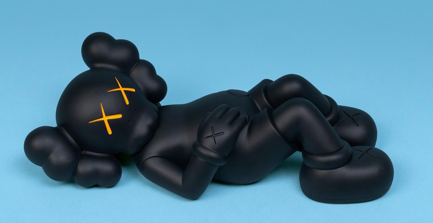 KAWS Compañero Negro de Vacaciones (KAWS Monte Fuji Japón): 
Esta escultura figurativa de vinilo muestra al característico COMPANION de KAWS en posición de descanso. Publicado por All Rights Reserved para conmemorar el debut de la figura de 40