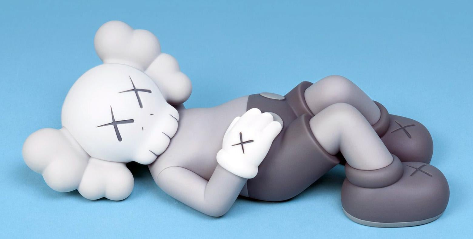 KAWS Grey Holiday Companion Japan (KAWS Mount Fuji Japan):
Questo pezzo figurativo KAWS, ormai esaurito, presenta il personaggio simbolo di KAWS, COMPANION, in posizione di riposo. Pubblicato da All Rights Reserved per commemorare il debutto della