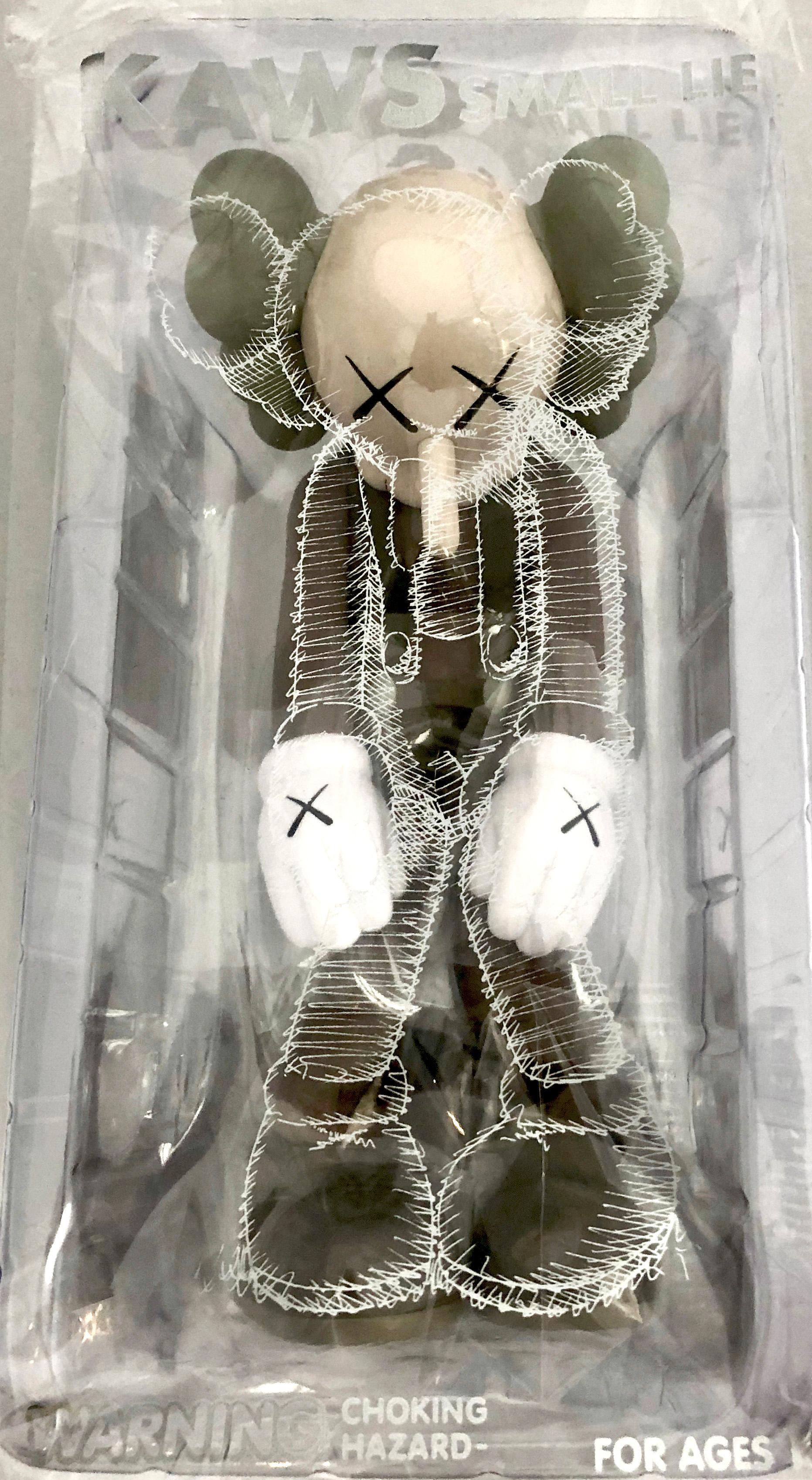 KAWS SMALL LIE Brown: 
Among KAWS’s signature “Companions,” Small Lie has the most childlike resonance. Clothed in overall shorts, the Pinocchio-inspired figure bows its head in shame as if hiding from a parent after creating trouble. KAWS debuted