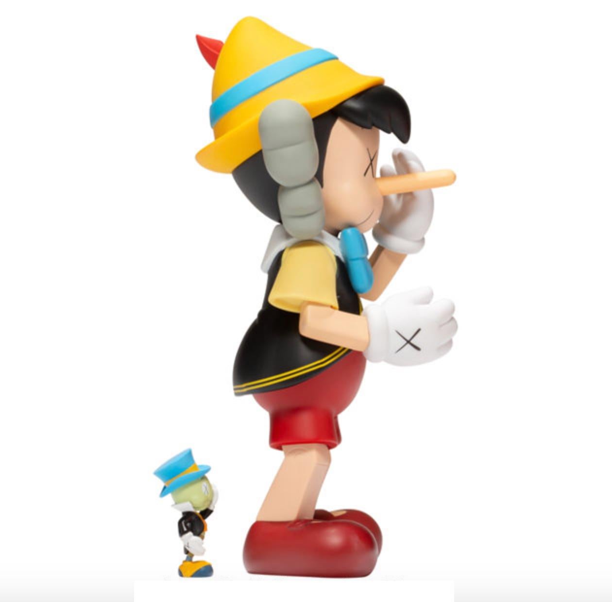 Artist: KAWS
Title: Pinocchio & Jiminy Cricket 
Pinocchio size: 25.5 x 12.7 x 11.3cm 
Jiminy Cricket size: 5.7 x 2.5 x 2.5cm
Medium: Vinyl Figure
Edition of 500
Stamped underfoot