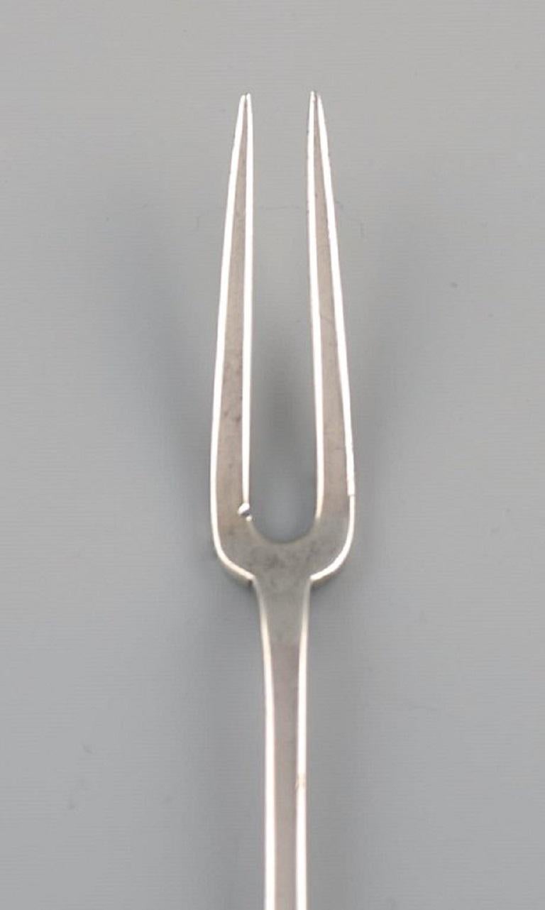 Kay Bojesen (1886-1958), Denmark. Cold meat fork in silver 830. 
1920s / 30s.
Length: 16 cm.
In excellent condition.
Stamped.
Our skilled Georg Jensen silversmith / goldsmith can polish all silver and gold so that it appears new. The price is