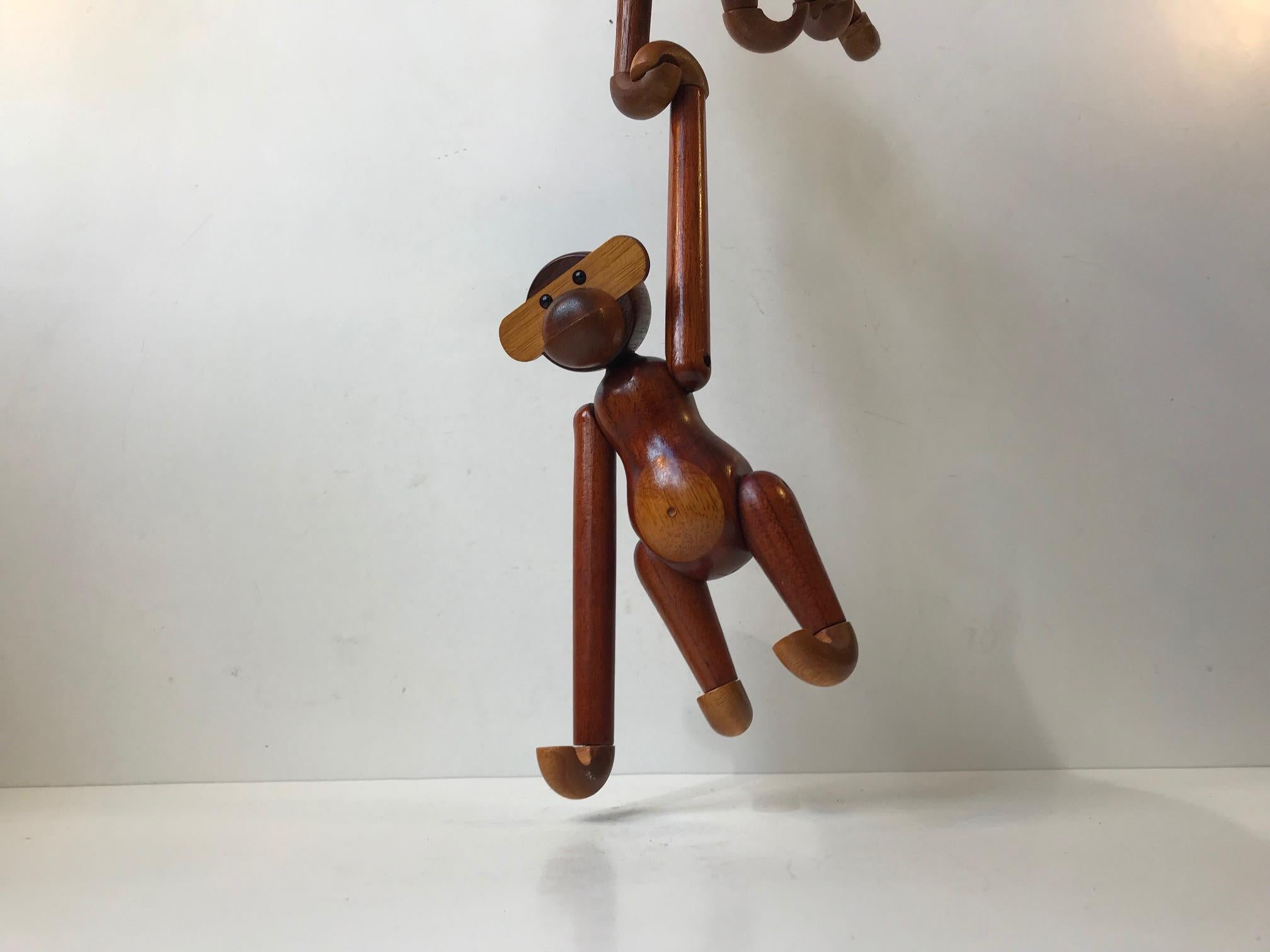 Set of two wooden monkeys designed by Kay Bojesen. Made of solid teak and limba wood. They features articulated limbs and movable heads The Kay Bojesen monkey has transformed kids rooms into jungles and sparked dreams of far-away places since 1951.