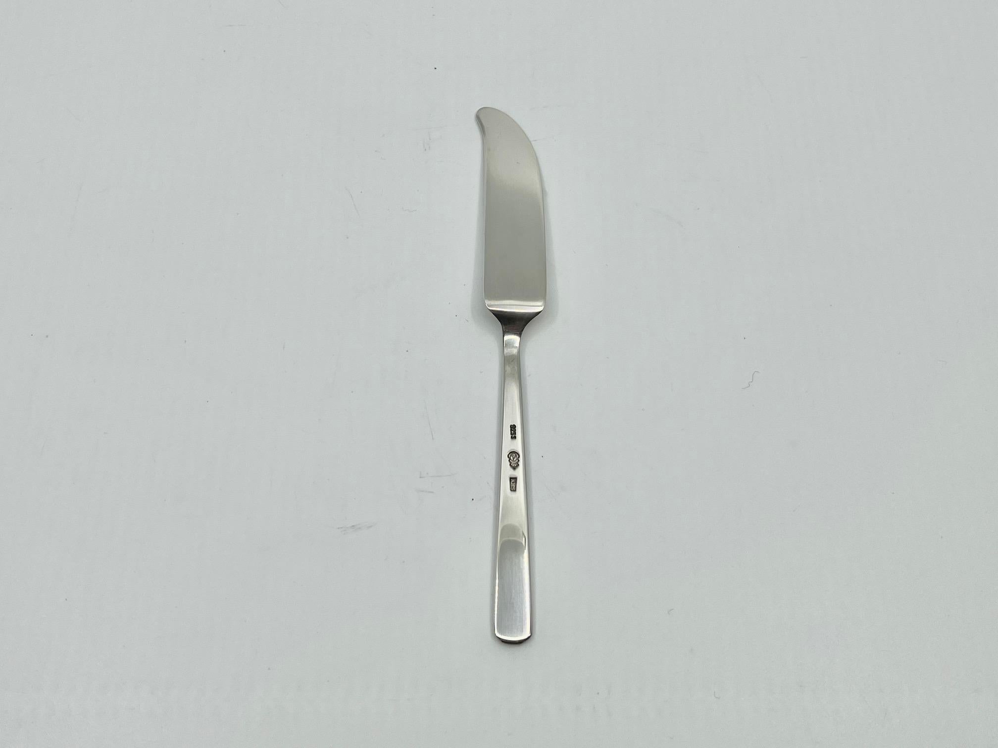 A sterling silver curved butter knife in the Grand Prix pattern, designed by Kay Bojesen in 1938.

Additional information:
Material: Sterling silver
Styles: Modern
Hallmarks: Marked with the Kay Bojesen buoy logo and “925S KBS”.
Dimensions: Measures