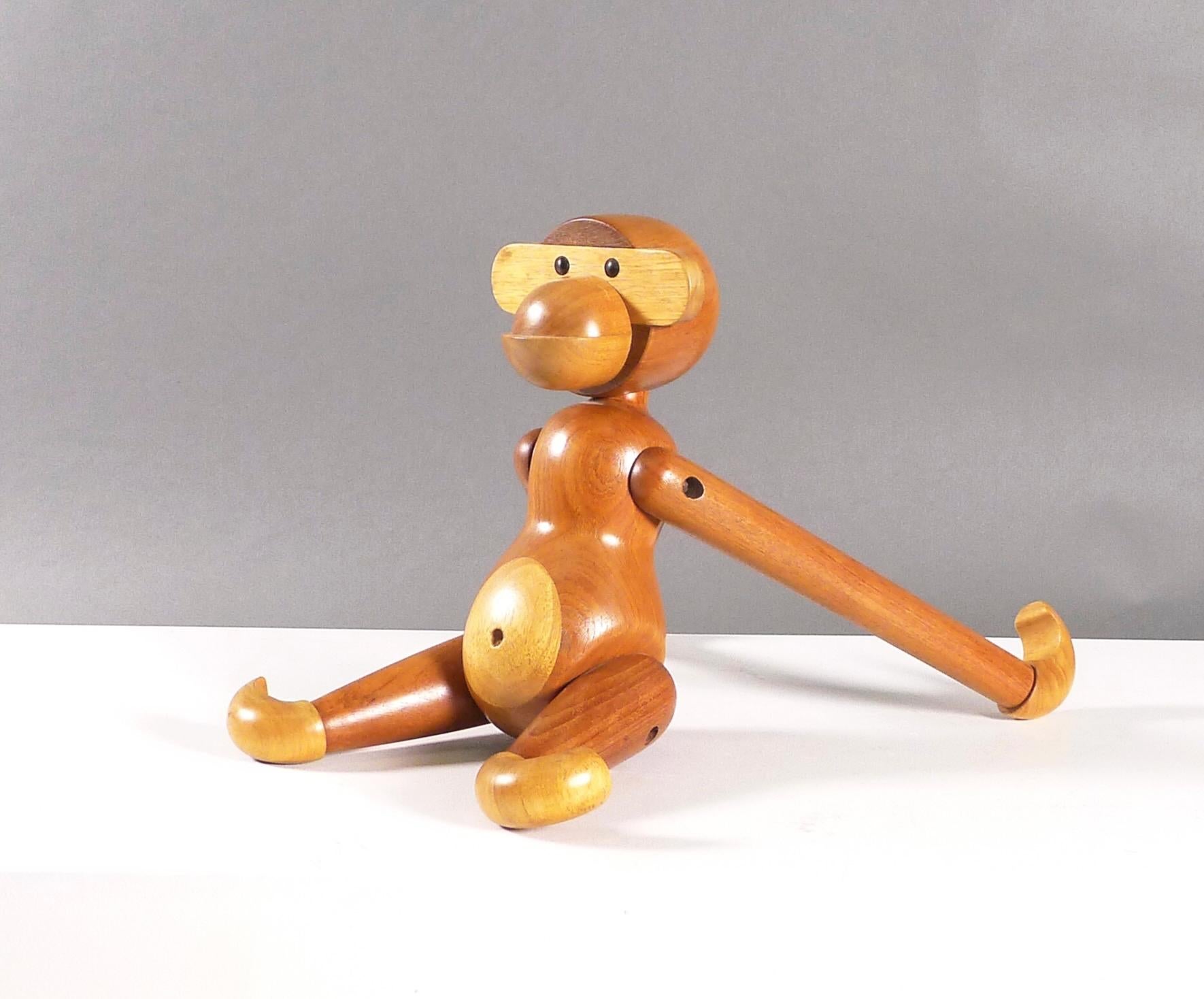 This is a vintage early example of the largest production monkey, designed by Kay Bojesen in 1951.  Constructed from teak and limba wood, the joints are articulated allowing the monkey to be placed in different positions or suspended.  This original