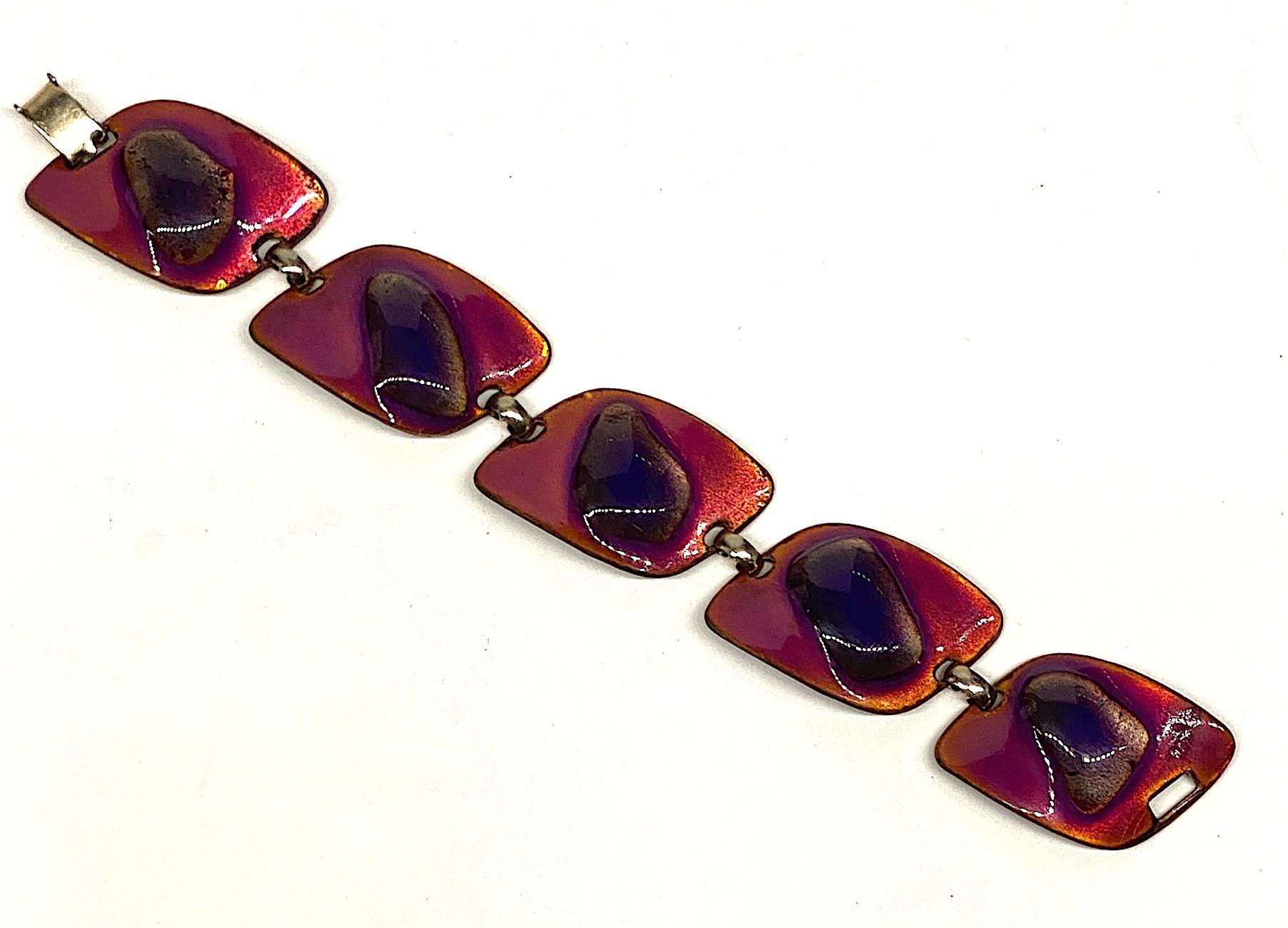 A lovely and colorful two tone purple enamel bracelet from the 1960s by Kay Denning. The bracelet is made up of five asymmetrical links and measures 1 inch wide and 7.5 inches long. The enameling involves the use of heating the dark purple glass
