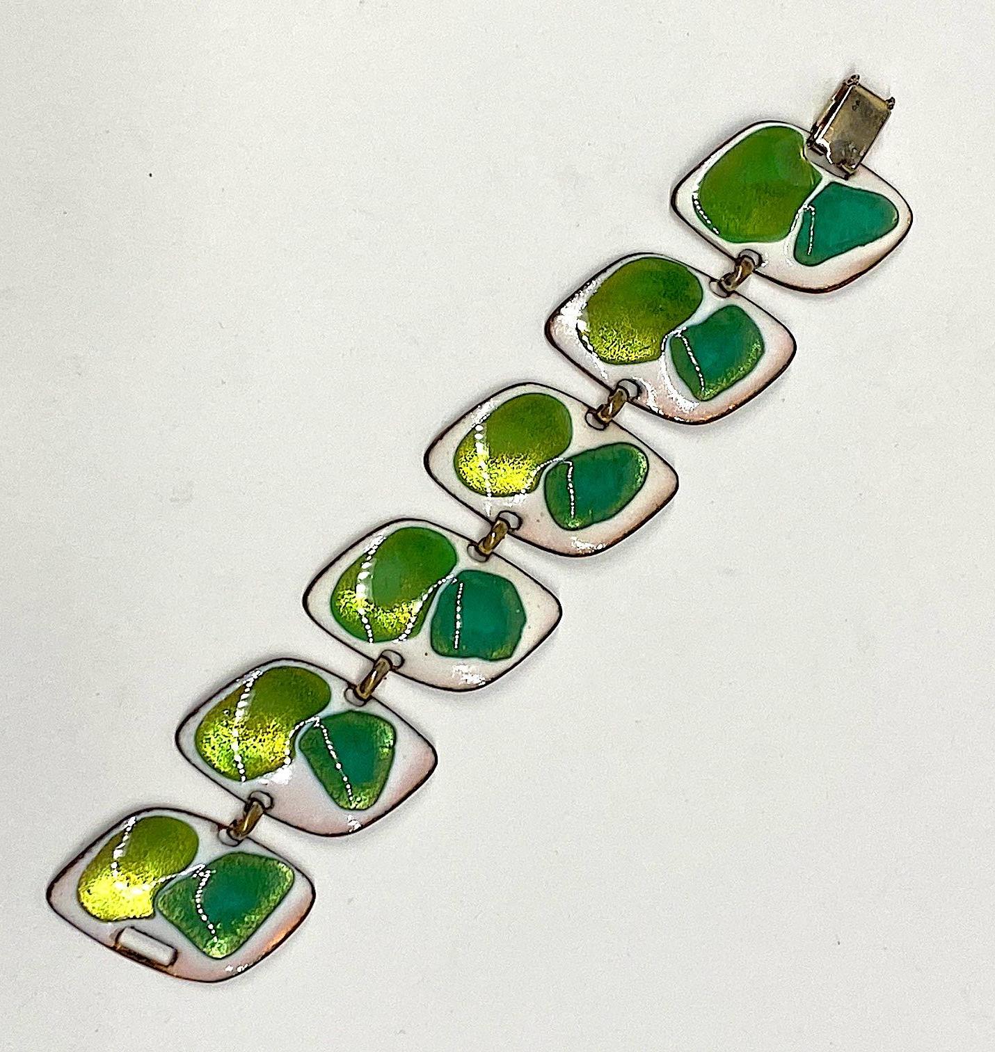 A bright and cheerful enamel bracelet from the 1960s by artisan Kay Denning. The bracelet measures 1.25 inches wide and 7.25 inches long. Each of the six links has a spot of irisescent green apple and a spot of grass green enamel on a background of