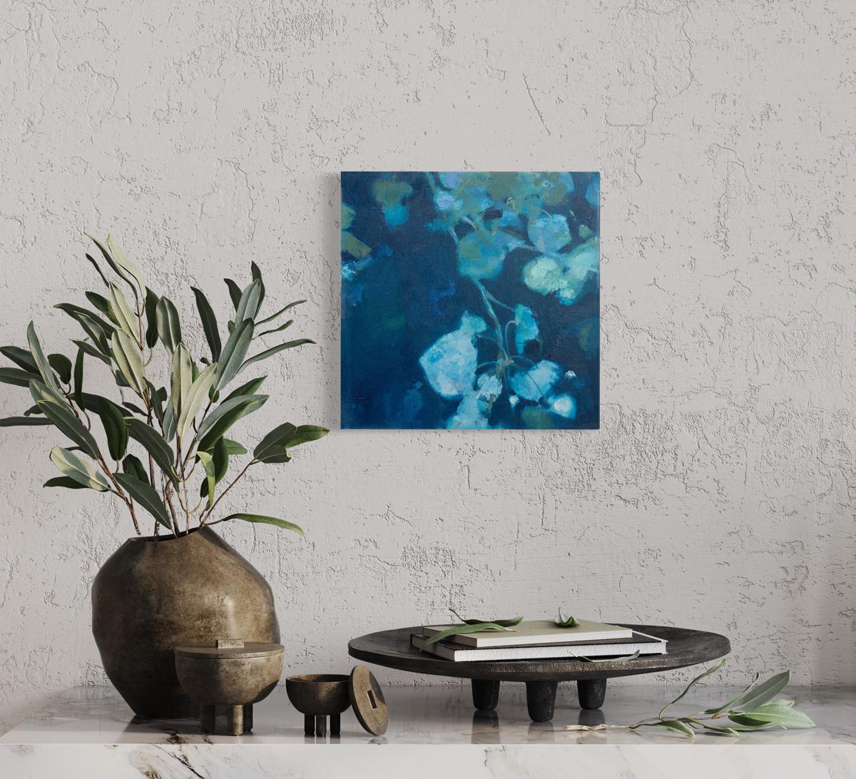 This small abstract floral painting by Kay Flierl is made with oil on canvas and features a cool blue palette. Light blue and earthy green abstracted botanical shapes fan out over a deep blue background. The painting has clean, painted sides, it is