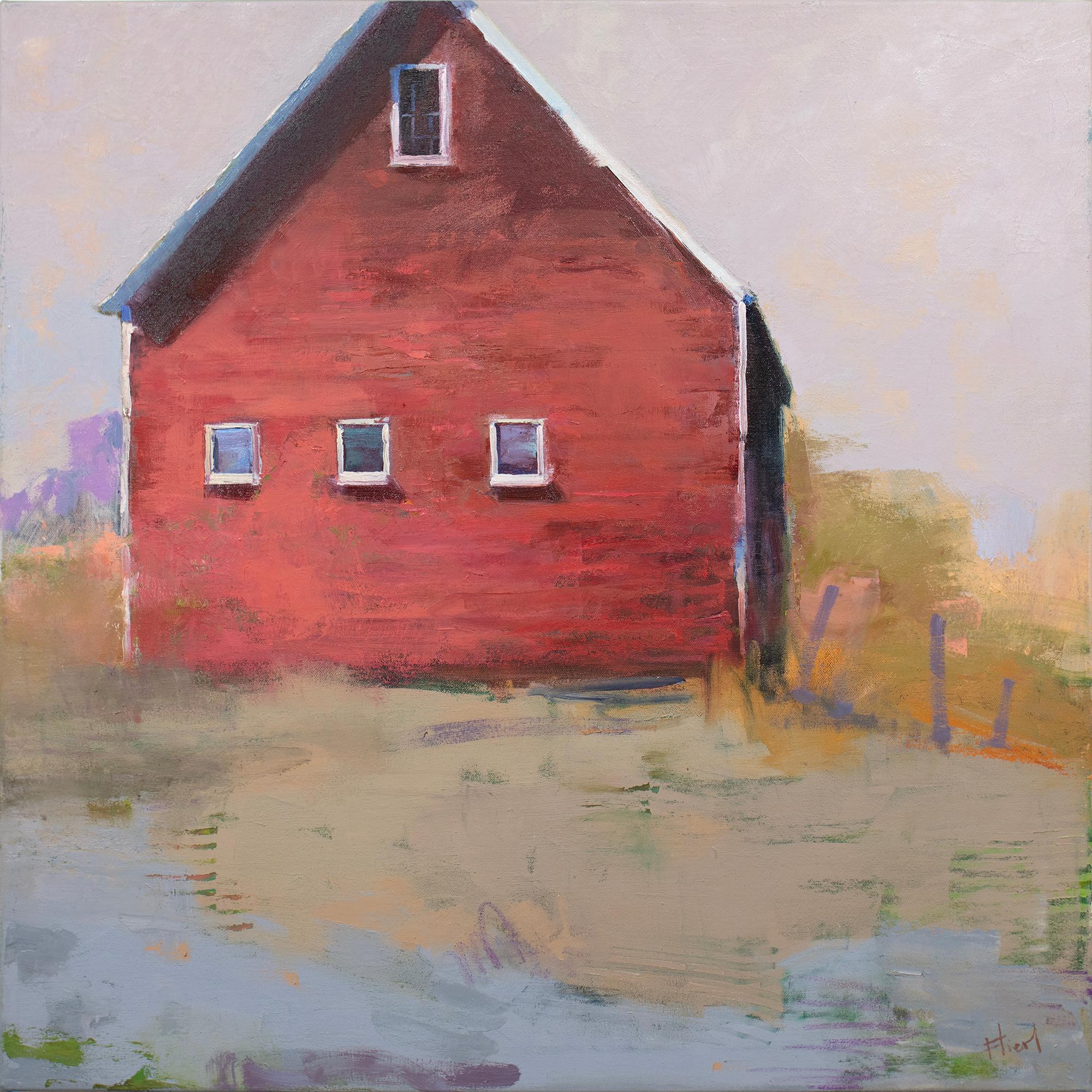 This landscape painting by Kay Flierl is made with oil paint on canvas and features a wam, earth-toned palette with subtle cool accents. It captures a rural scene, with a larger red barn on a hill surrounded by abstracted yellow and brown grass and