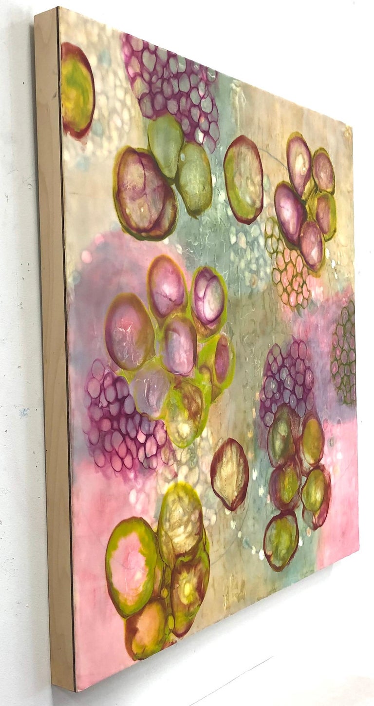 Kay Hartung’s “Bio Flow 5” is a 30 x 30 x 2.5 inch encaustic painting composed of transparent layers depicting microscopic forms. In colors of pink, maroon, pale green and pale ochre, the layers create a sense of luminous depth. The painting is