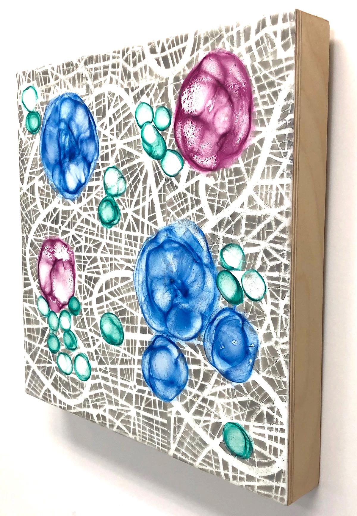 Kay Hartung’s “Bio Networks 6” is a 12 x 12 x 1.5 inch abstract encaustic painting depicting floating microscopic forms on a highly patterned background. In colors of pink, blue green, grey and white, the composition has a striking sense of depth.