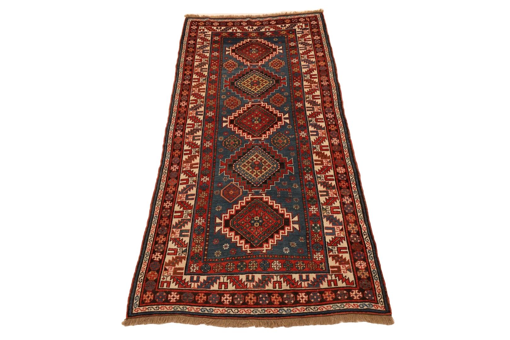 Introducing the Kazak Cornflower Blue Diamond Medallion Runner - a true masterpiece of craftsmanship and design. This exquisite rug boasts a stunning cornflower blue background that forms the canvas for a symphony of colors and patterns, making it a