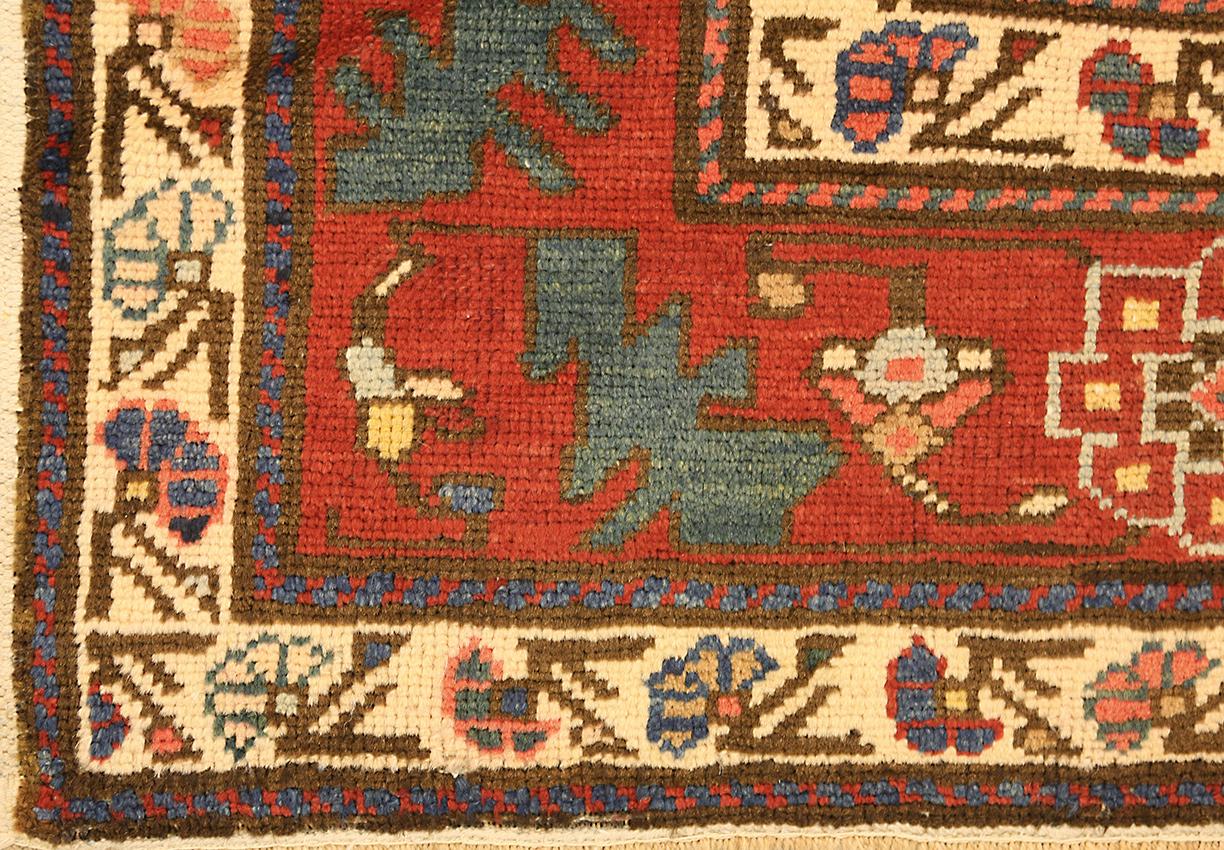 This gorgeous antique Caucasian Kazak Adler rug is sure to add a touch of luxury to any home. Woven circa 1920, it features a beautiful geometric design with bold pattern and deep blue color field. The geometric shape features a soft and inviting,