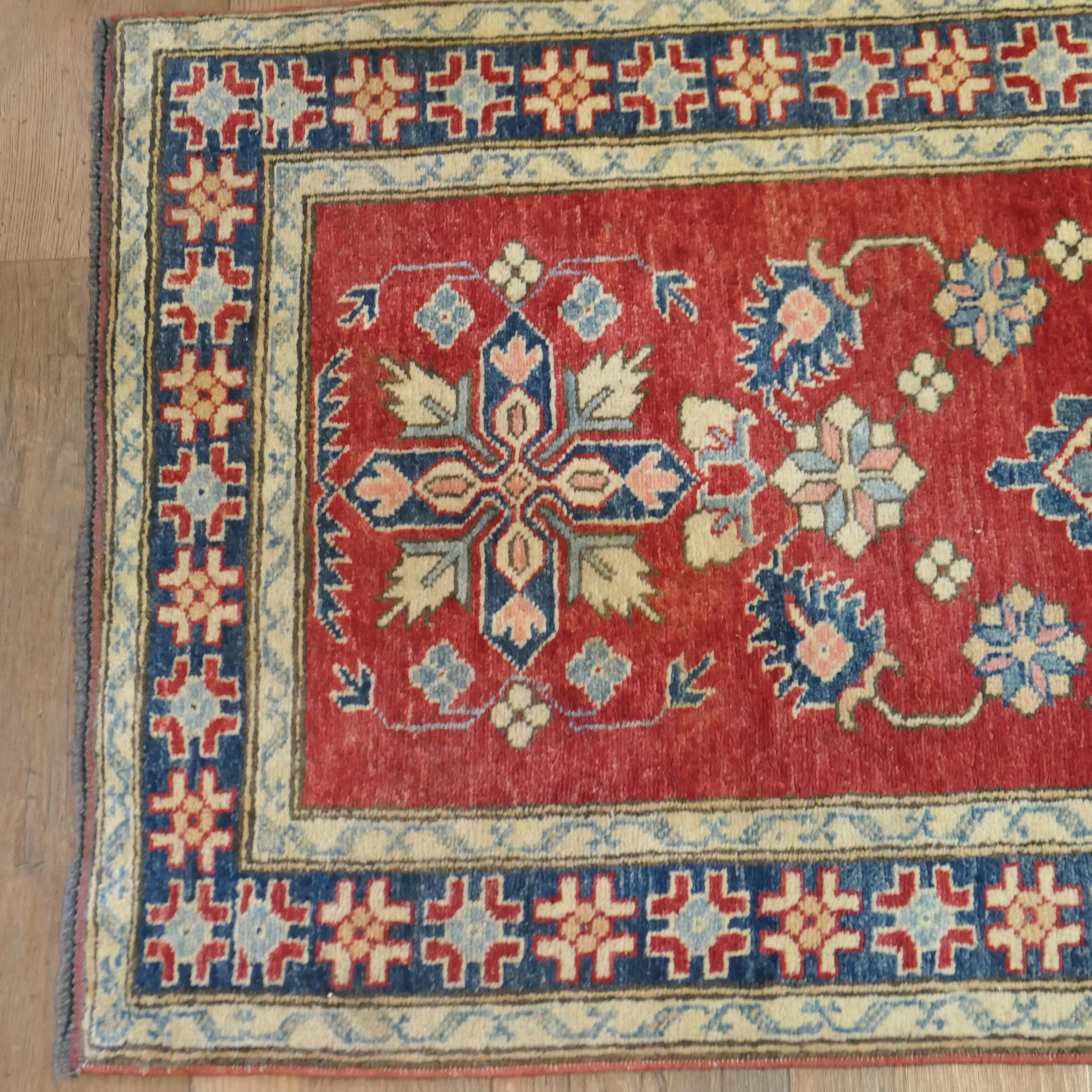 Kazak Handgewebter 12ft-Teppich-Läufer in traditionellem Design

Ein prächtig aussehendes Stück aus dem frühen 20. Jahrhundert mit einer schönen Farbpalette aus leuchtendem Rot und blauen Schattierungen.  
Der Woll-Läufer hat ein zentrales