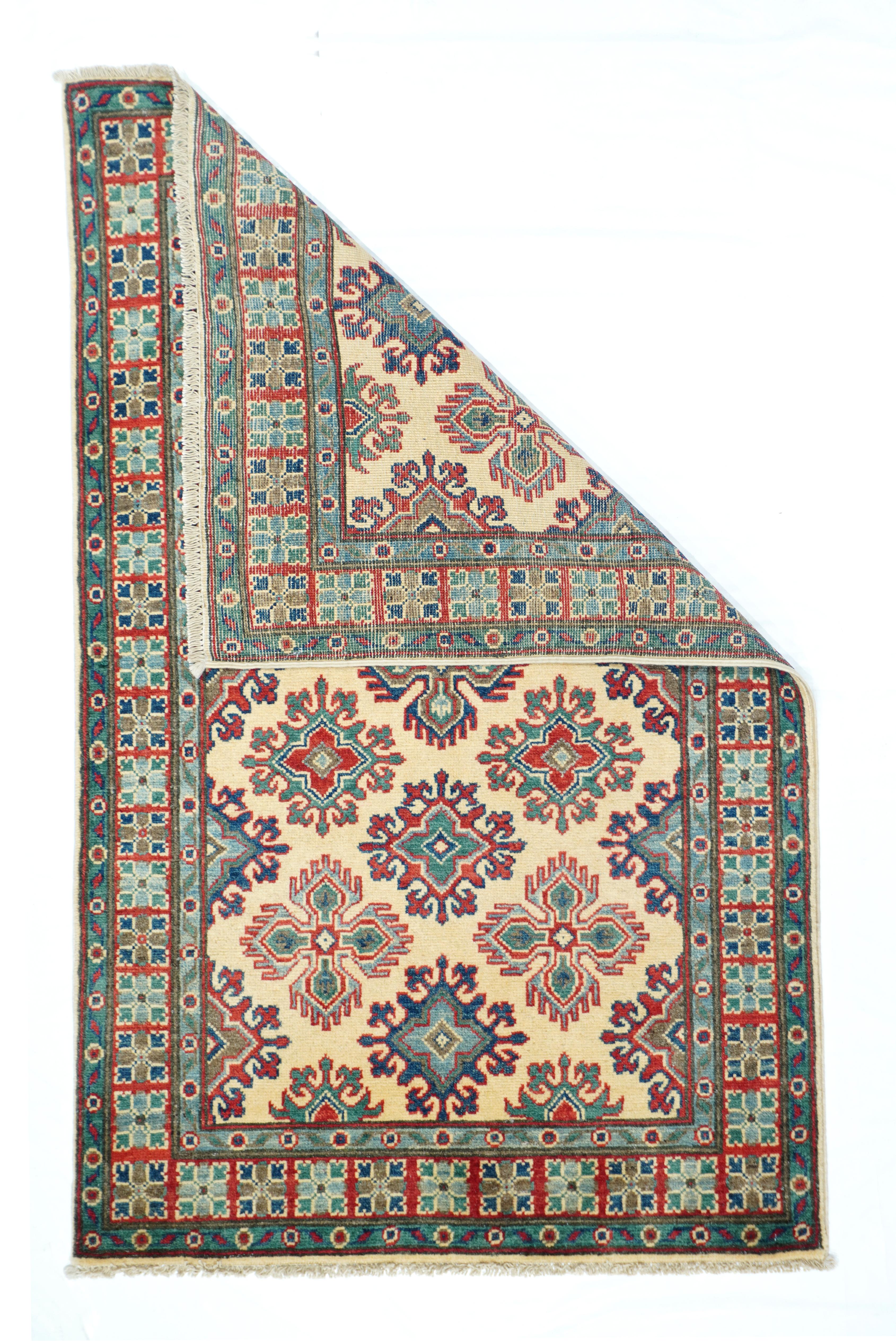 Kazak rug 3' x 5'. The straw-ivory field shows three complete offset columns of alternating palmette crosses and smaller cruciform with radiating pairs of hooks. Central palmete cross shows a comb finge. Partial crosses in lateral columns along the