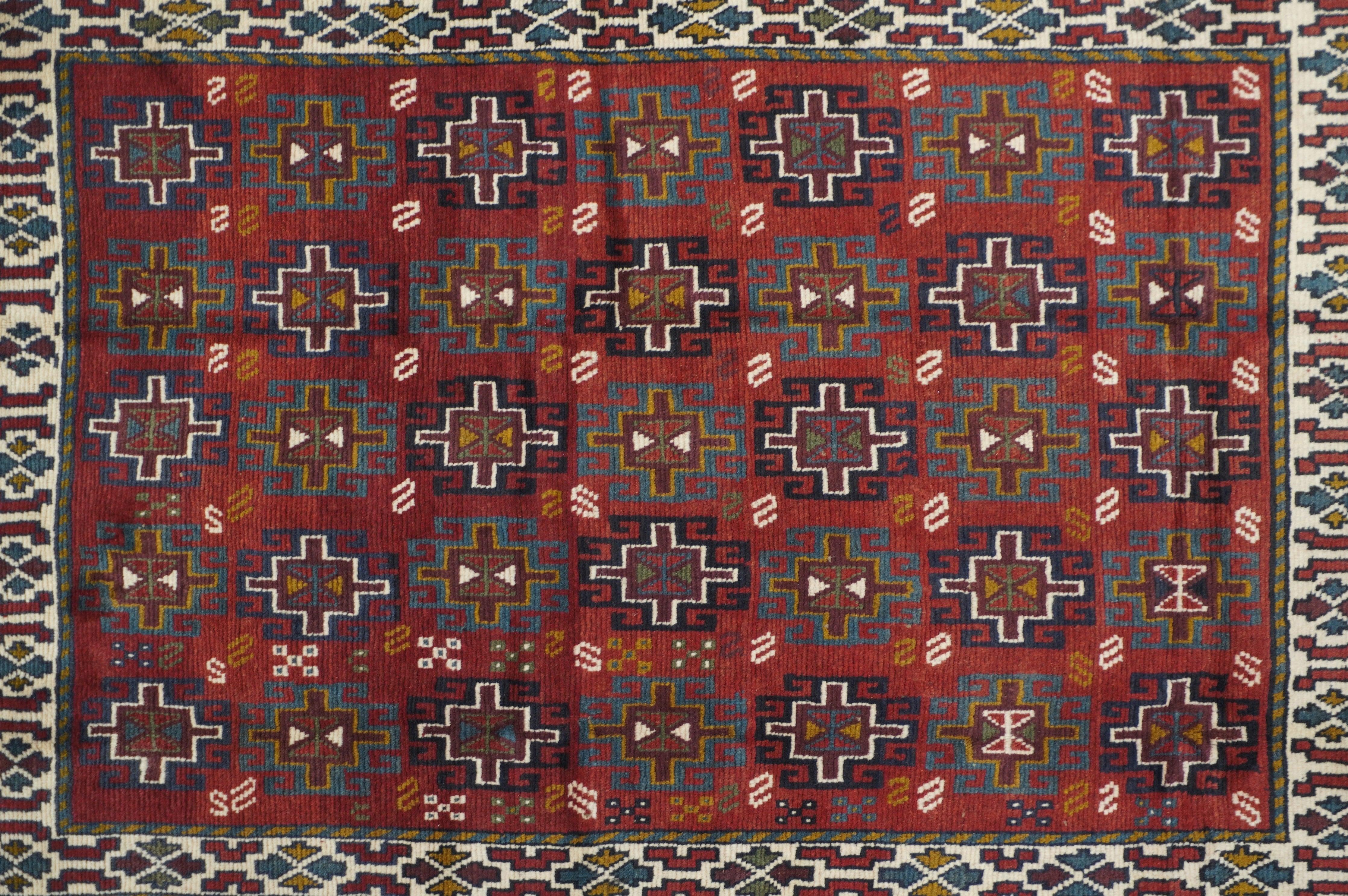 Kazak Teppich 3'10'' x 5'9''. Streuung mit einem mahagoniroten Feld und fünf Säulen aus einfachen Memling-Gulis abwechselnd in Grün und Marineblau. Ecru Streifen Stil Grenze von vier Pfeilspitze Geräte und Füllstoff geometrische Wolke Bands. Intakte