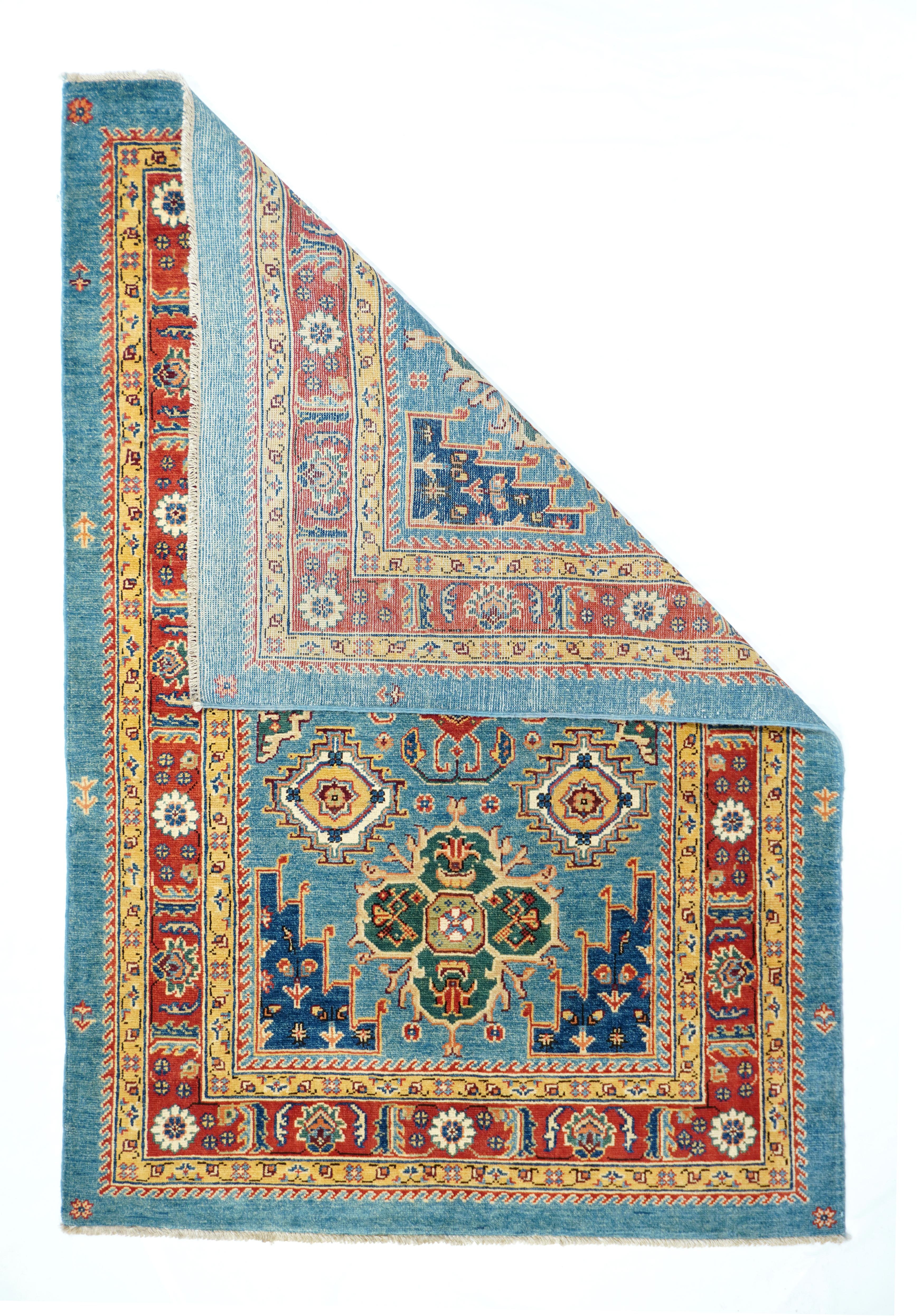Kazak Rug 4' x 6'. This delightfully colorful modern rug shows an interesting combination of Caucasian and Persian Heriz designs. The red border features rosettes alternating with fringed leaves inn the Heriz style while the light blue field shows