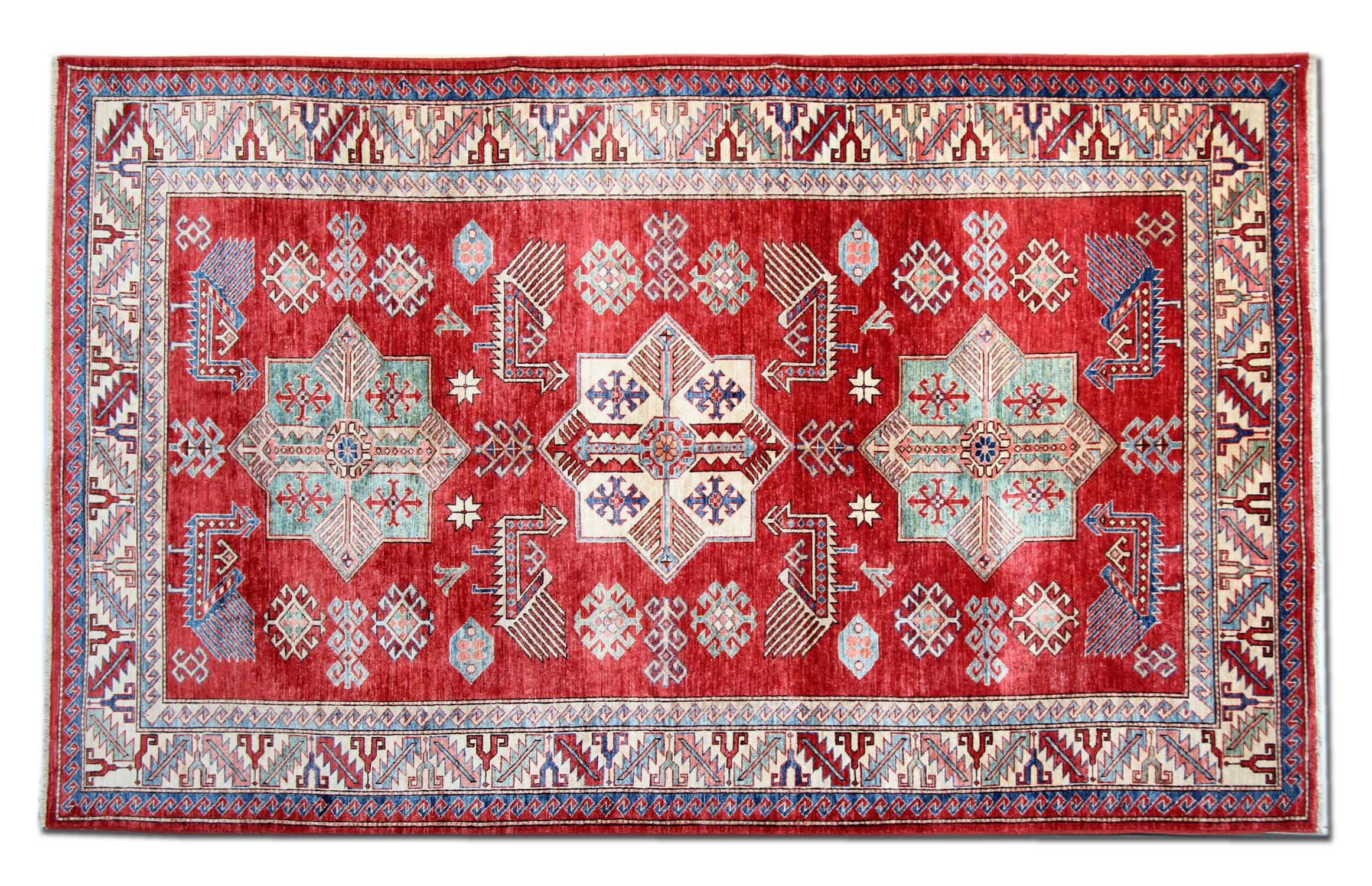 This Kazak red rug has a traditional border with three medallions. The central area of this tribal rug symbolises a garden of paradise protected by the 'walls' of geometric rug patterns, including a few peacocks. Traditional rugs would complement
