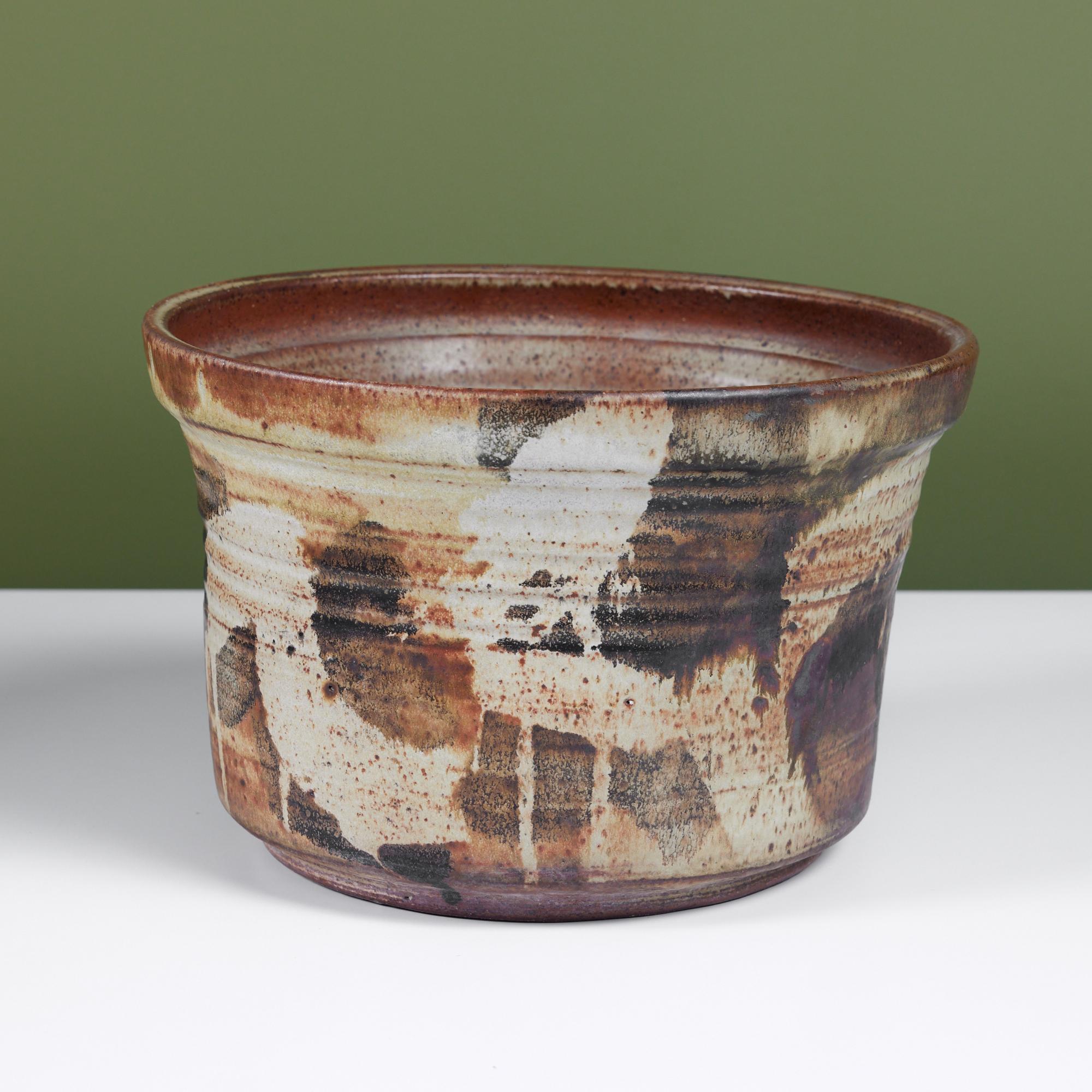 Hand thrown stoneware planter by American ceramicist, Kazuko Matthews. This planter features a layered brush stroke glaze in brown, cream and olive tones. Signed by the artist.

Dimensions
12