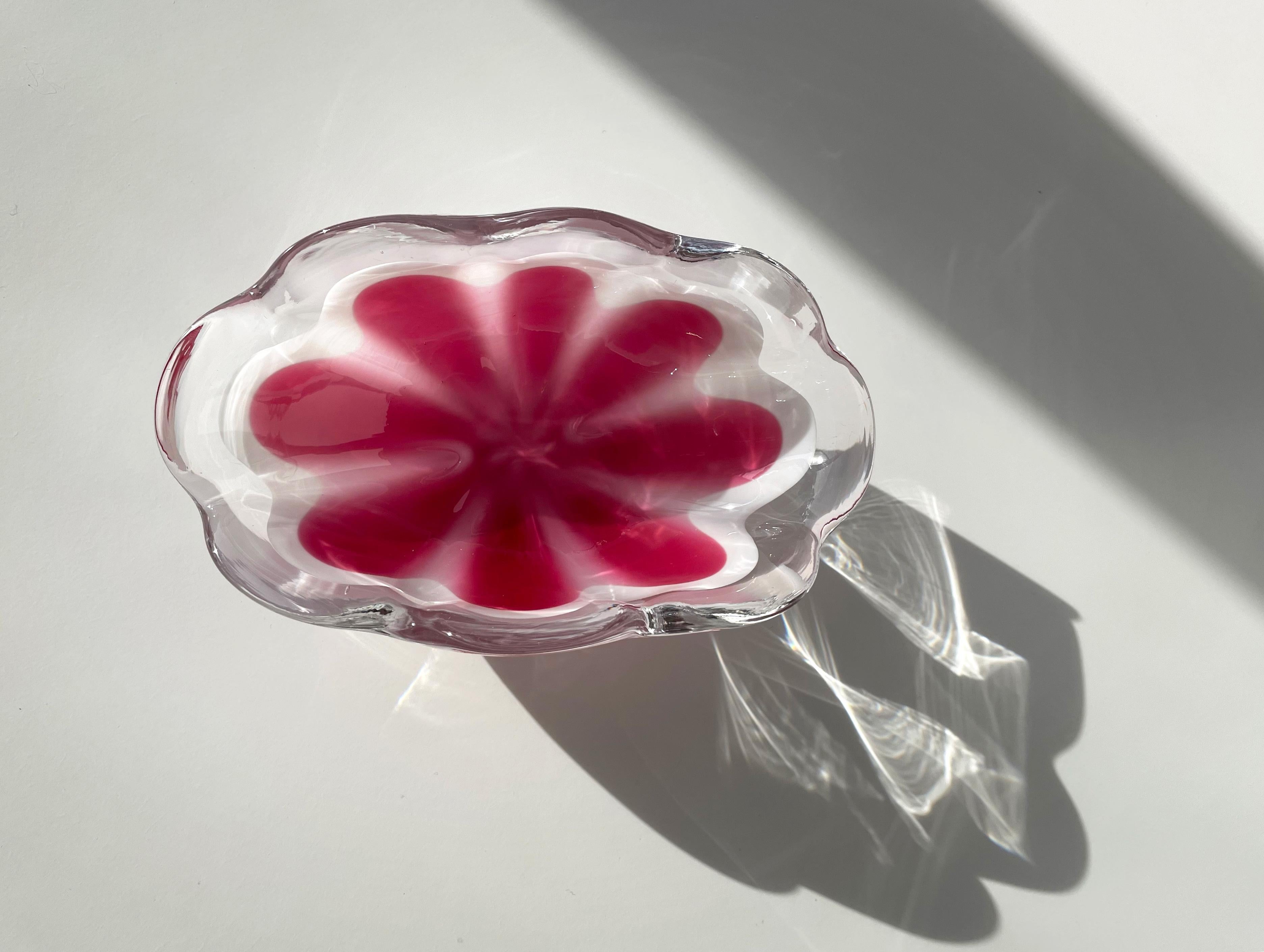Swedish Mid-Century Modern oval art glass bowl with soft, organic shapes from the Coquille series designed by Paul Kedelv and manufactured by Flygsfors in the late 1950s. Bright pink and milky white glass encased in clear glass. Round waves around