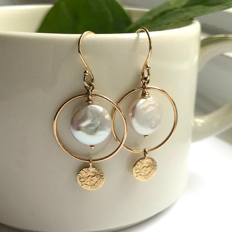 These unique Halo Earrings from contemporary jewelry artist Keiko Mita are handmade from 14 Karat Yellow Gold. The designer earrings, which are 39 mm long and 18 mm wide, feature 11 mm round Freshwater Coin Pearls. The playful earrings are from the